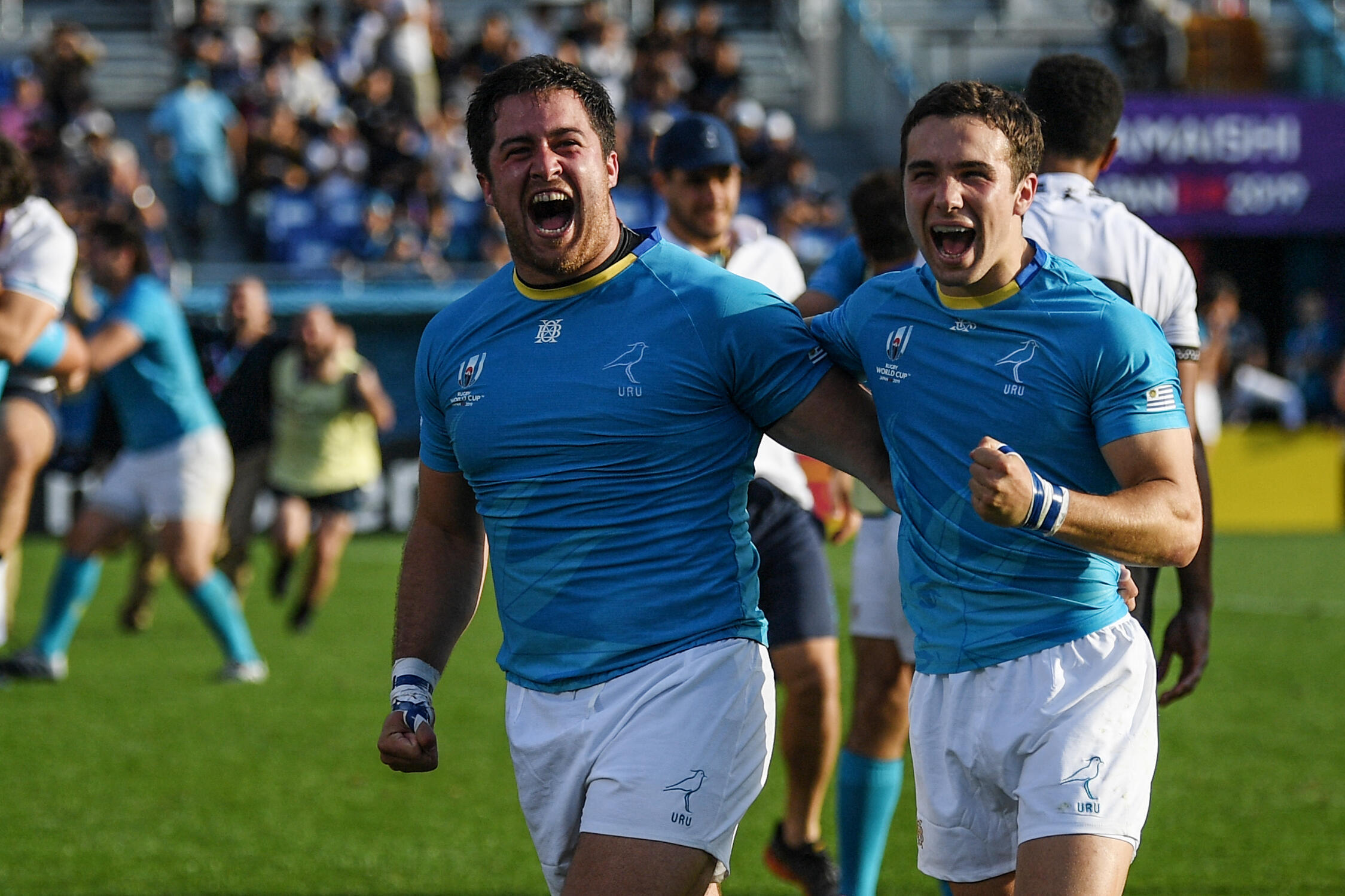 Uruguays Facundo Gattas (links) und Felipe Etcheverry feiern nach ihrem historischen Sieg über Fidschi bei der Weltmeisterschaft 2019.