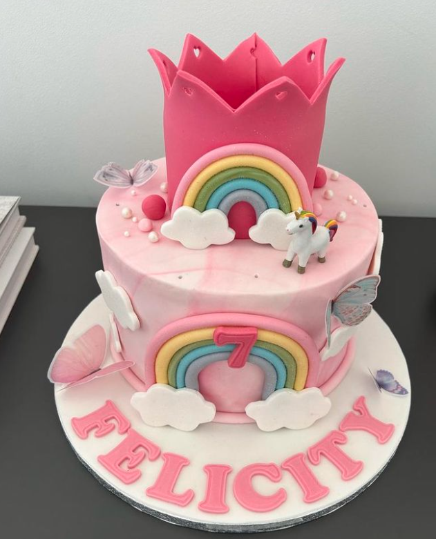 Felicity hatte eine rosafarbene Geburtstagstorte mit Regenbogen und Einhorn, die die Familie verzehrte