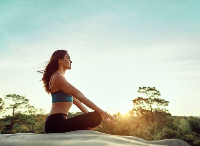 Fitte Frau meditiert am sonnigen Morgen, Konzept, wie man fit bleibt, ohne Sport zu treiben