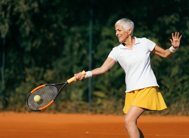 Reife Frau spielt Tennis, die schlimmsten Übungen gegen Arthritis