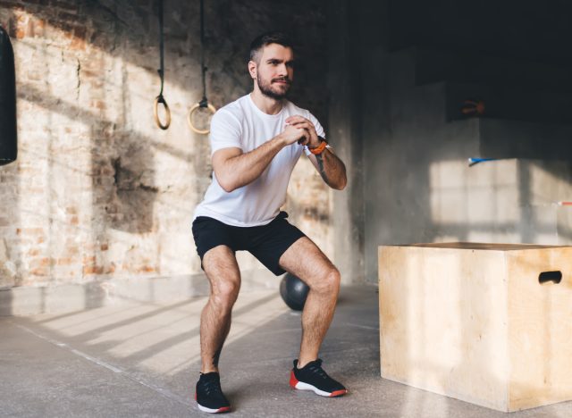 Fitter Mann macht Kniebeugen, Konzept von Körpergewichtsübungen für Männer in den Dreißigern