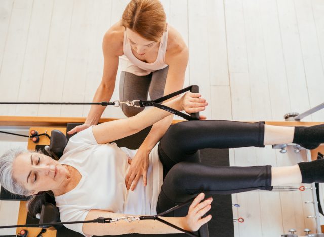 Frau macht Pilates-Übungen in Rückenlage