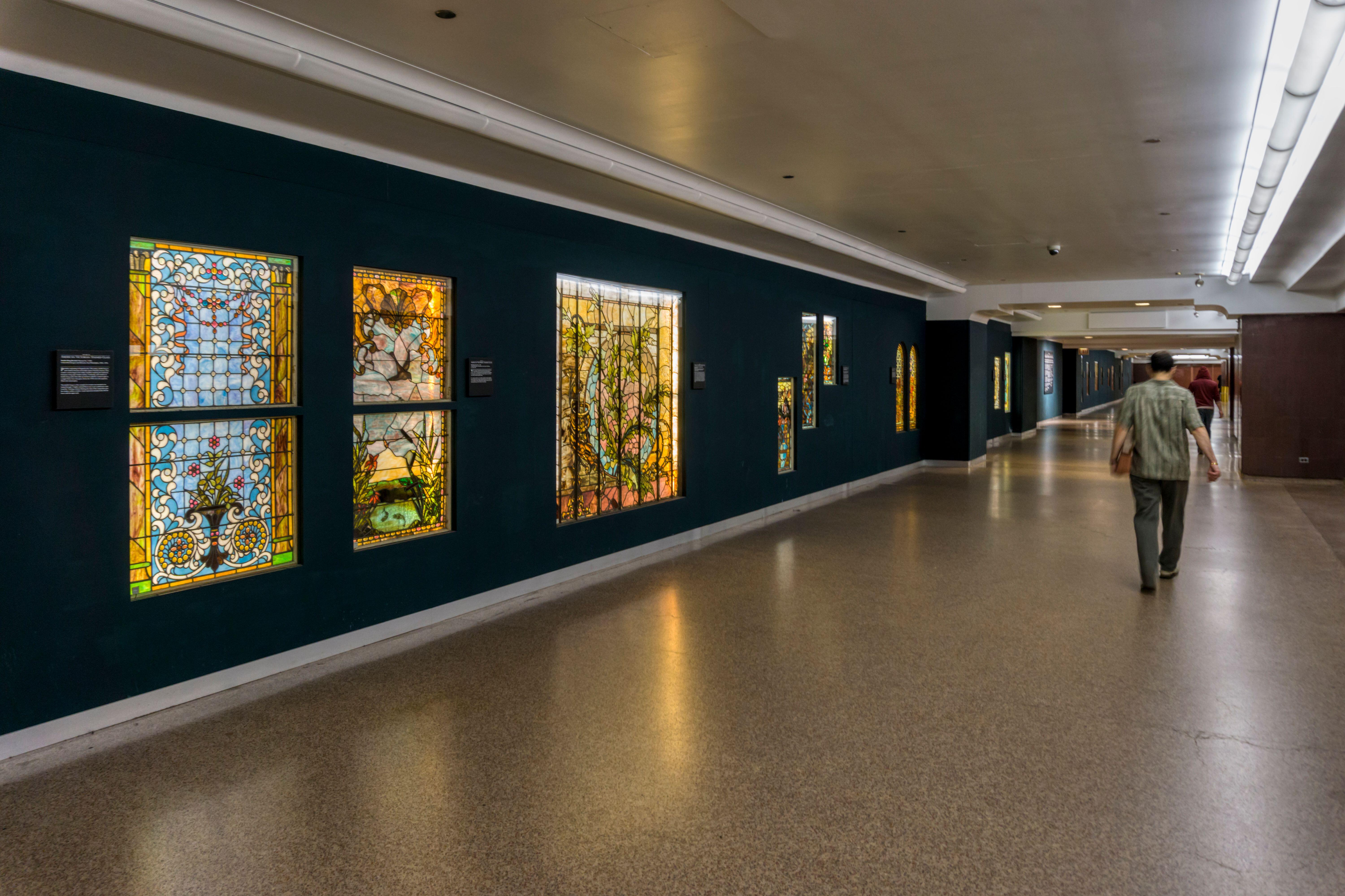 Buntglasfenster säumen die Wände neben Restaurants, Salons und Geschäften