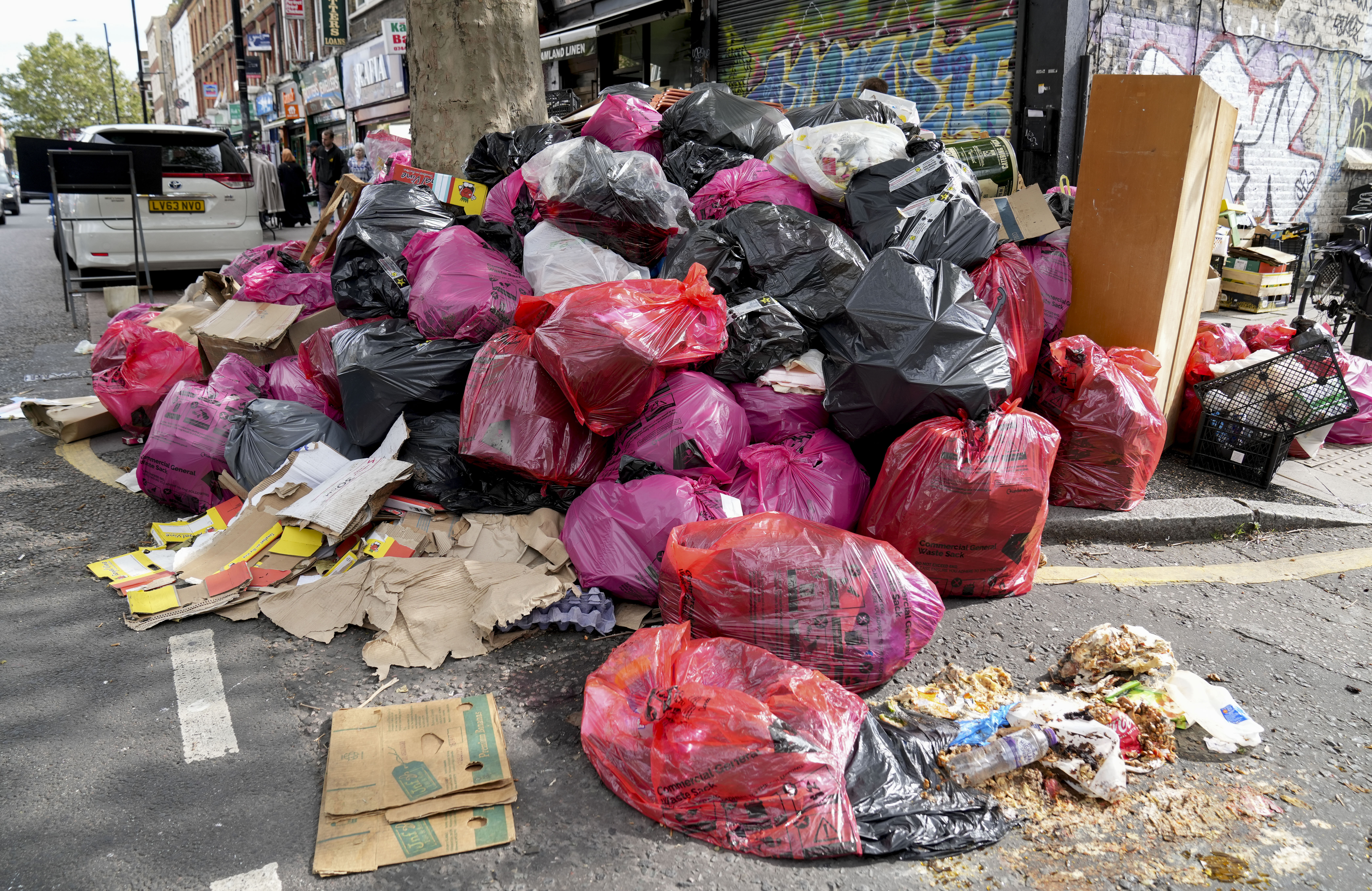 Ein Berg großer Säcke mit verrottendem Müll ergießt sich auf die Straße im Osten Londons