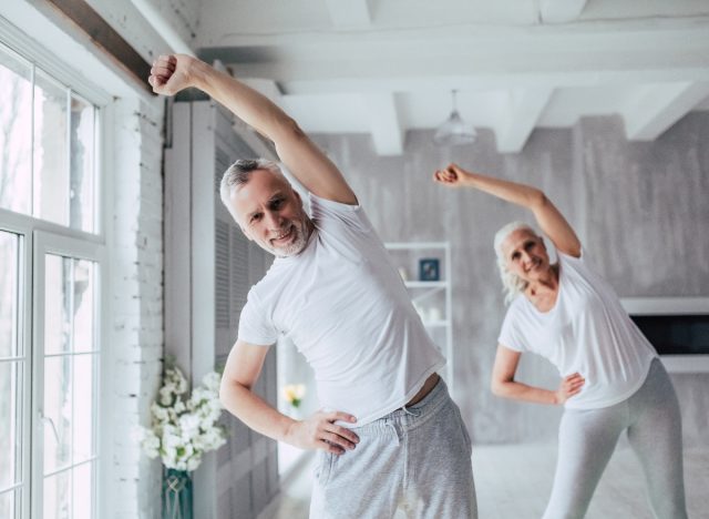 Älteres älteres Paar, das Yoga-Mobilitätsübungen macht
