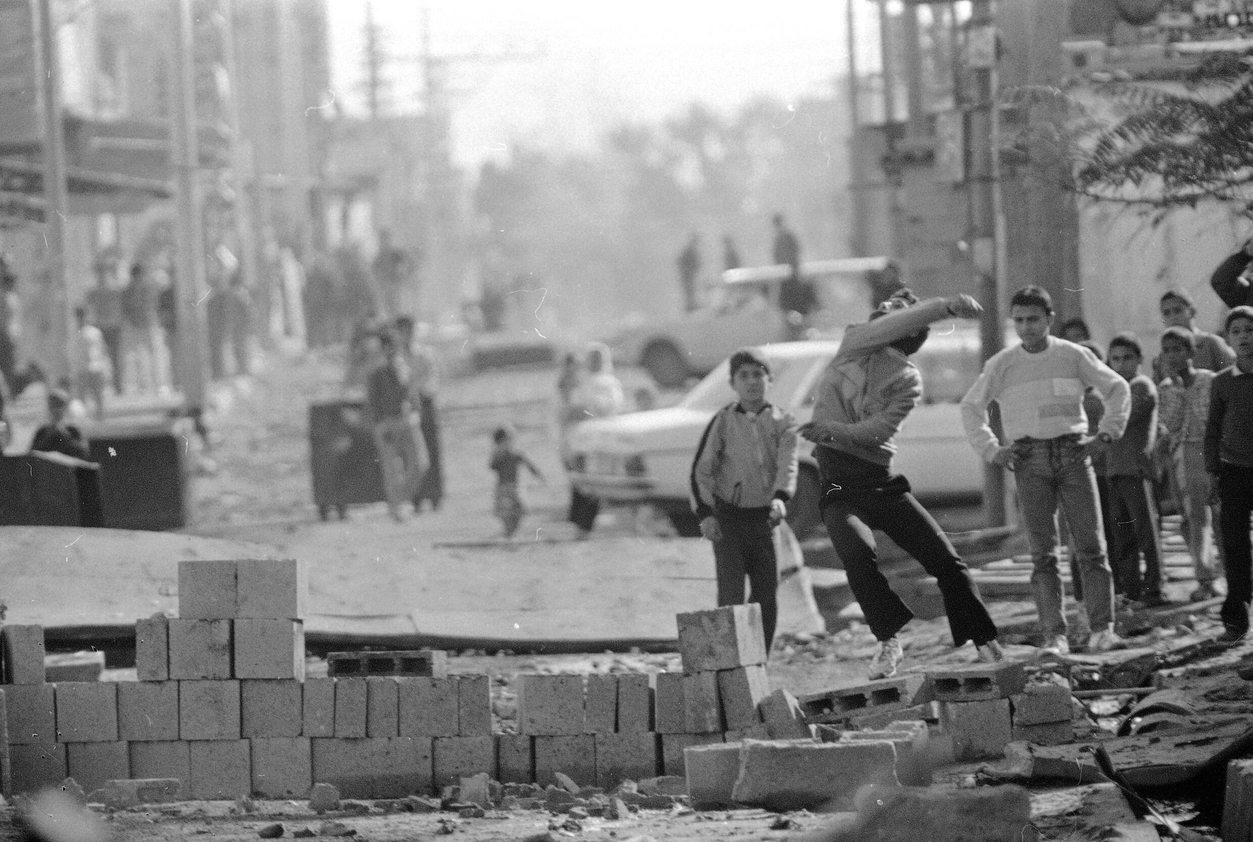 Am 19. Dezember 1987 wirft ein Jugendlicher am Eingang des Flüchtlingslagers Bureij im besetzten Gazastreifen Steine ​​in Richtung israelischer Soldaten.