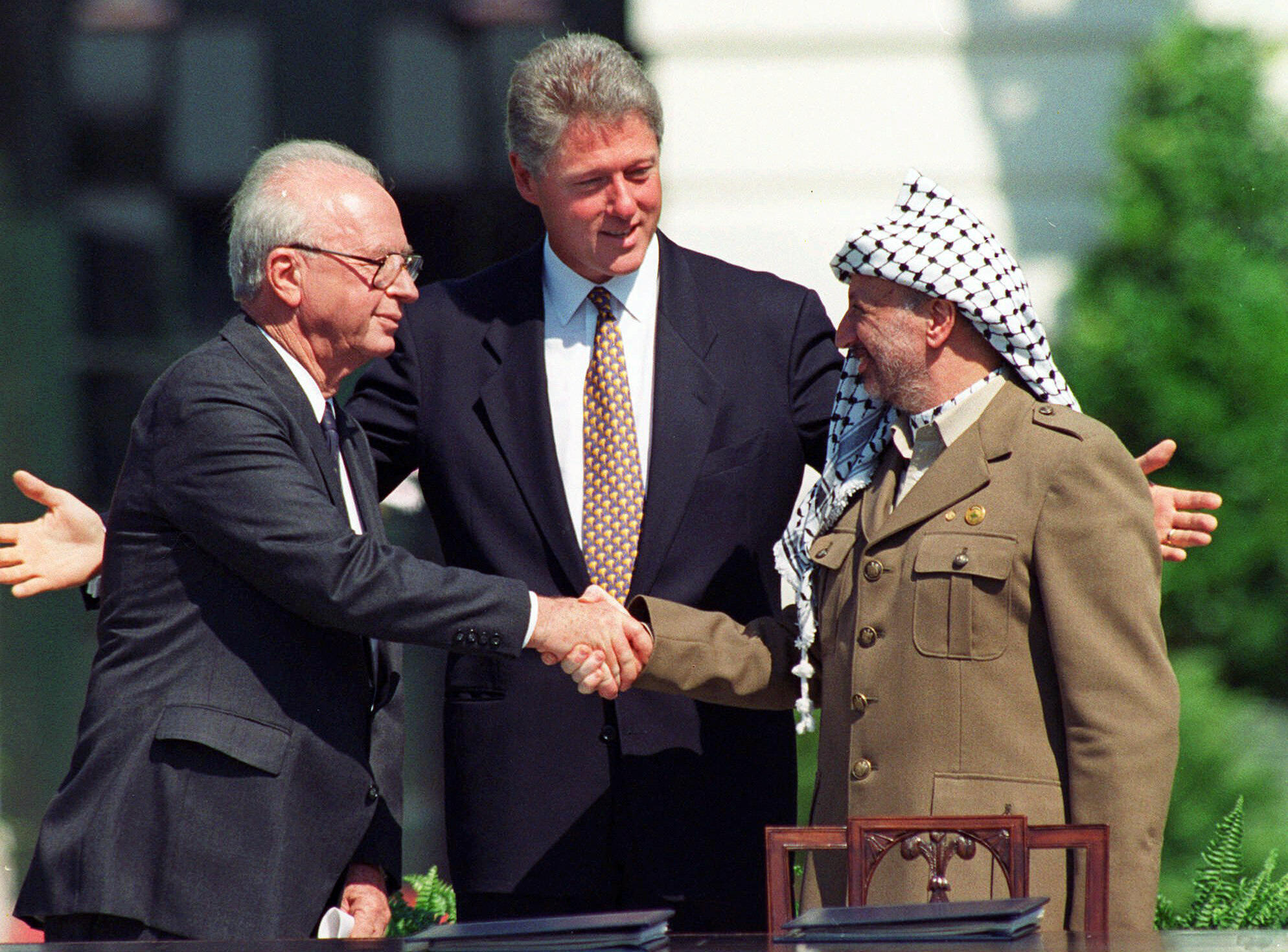 US-Präsident Bill Clinton leitet am 13. September 1993 in Washington die Zeremonien im Weißen Haus anlässlich der Unterzeichnung des Friedensabkommens zwischen Israel und den Palästinensern mit dem israelischen Premierminister Yitzhak Rabin (l.) und dem Palästinenserführer Jassir Arafat (r.).