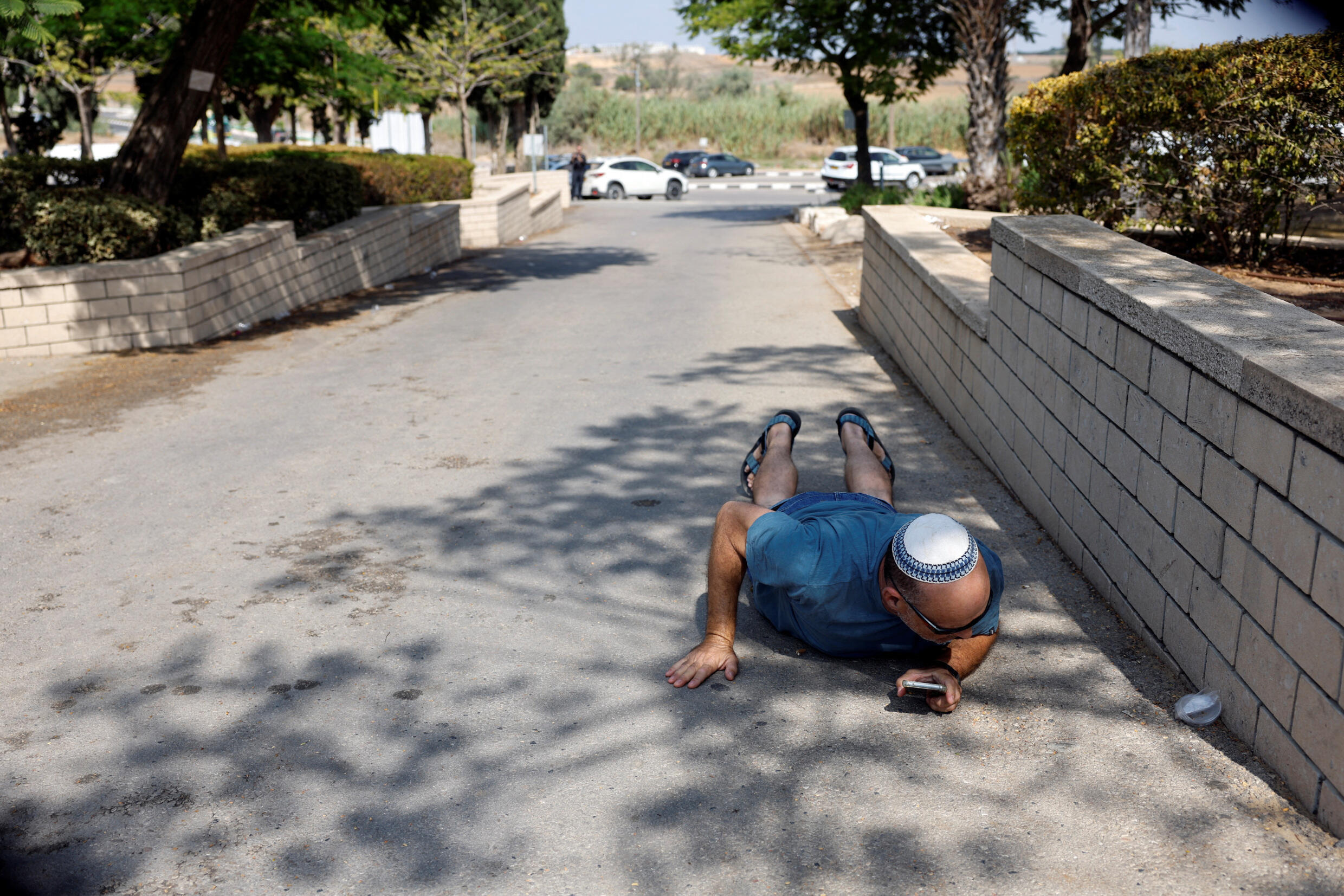 Ein Mann geht in Deckung, während Sirenen Zivilisten darauf aufmerksam machen, dass Raketen auf Israel abgefeuert wurden, Aschkelon, Südisrael, 10. Oktober 2023.