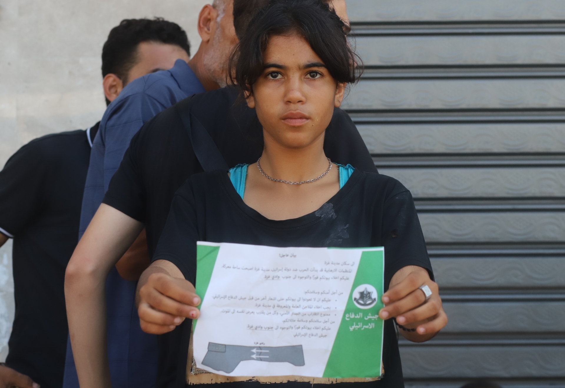 Ein Mädchen hält ein Flugblatt in der Hand, das von israelischen Armeeflugzeugen abgeworfen wurde und die Bewohner vor einem „unmittelbar bevorstehenden Angriff“ warnt.