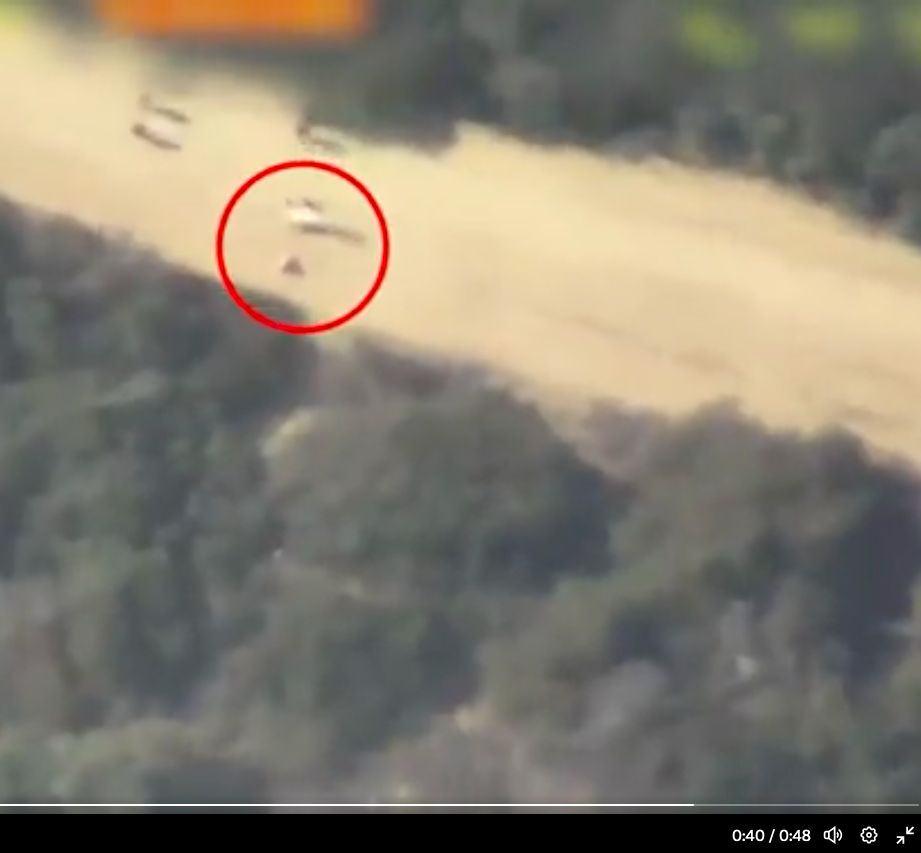 Screenshot des IDF-Videos bei 0'40.  Von einer der sechs vorrückenden Figuren ist ein kleiner Blitz zu sehen, und einen Moment später ist ein größerer Blitz in der Nähe einer der liegenden Figuren zu sehen.