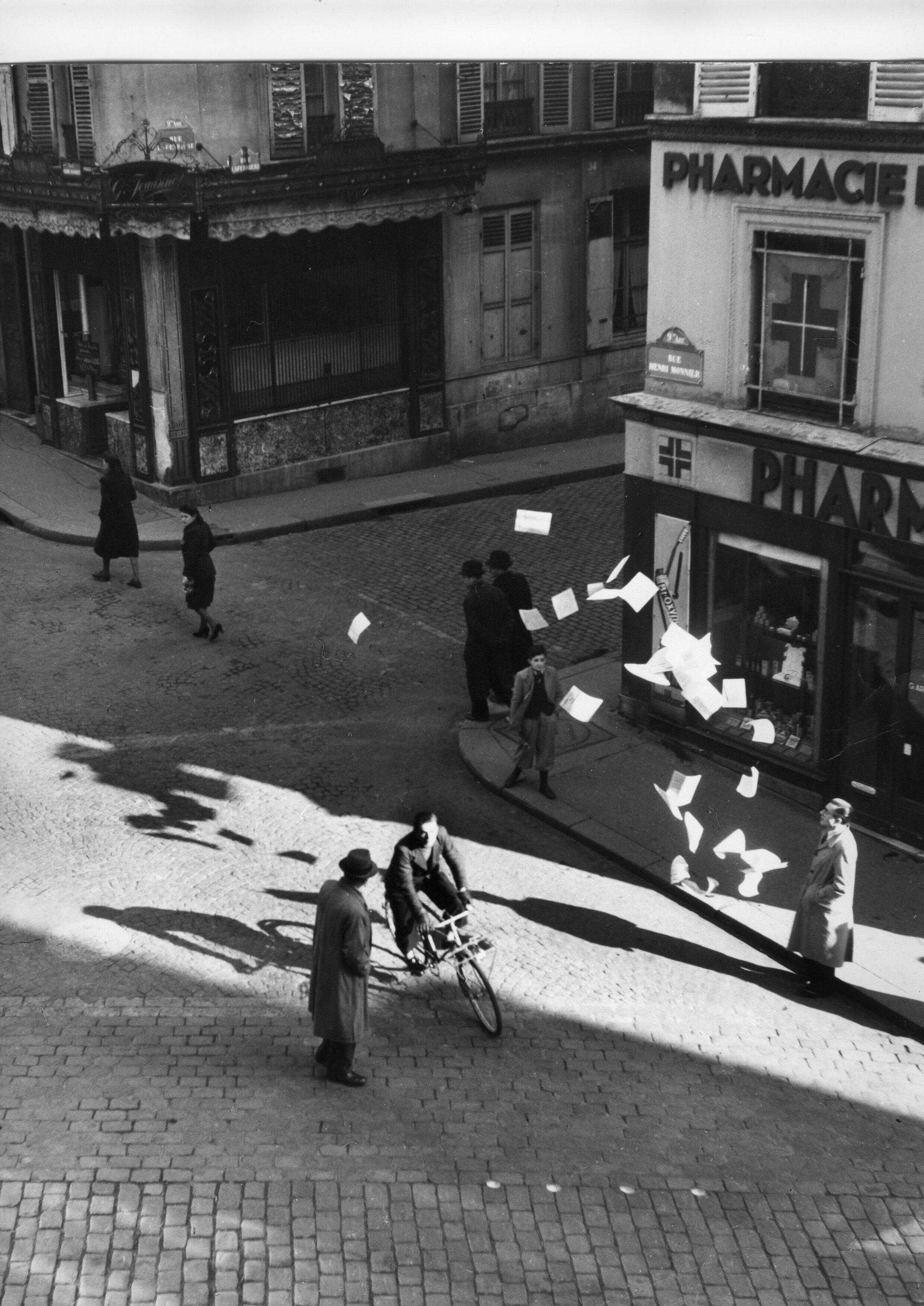 Ein Widerstandskämpfer verteilt Flugblätter in der Pariser Rue Henry Monnier als Teil einer rekonstruierten Fotoserie von Robert Doisneau über geheime Drucker im Zweiten Weltkrieg |  AAMRN-Sammlung, Museum des nationalen Widerstands in Champigny-sur-Marne.