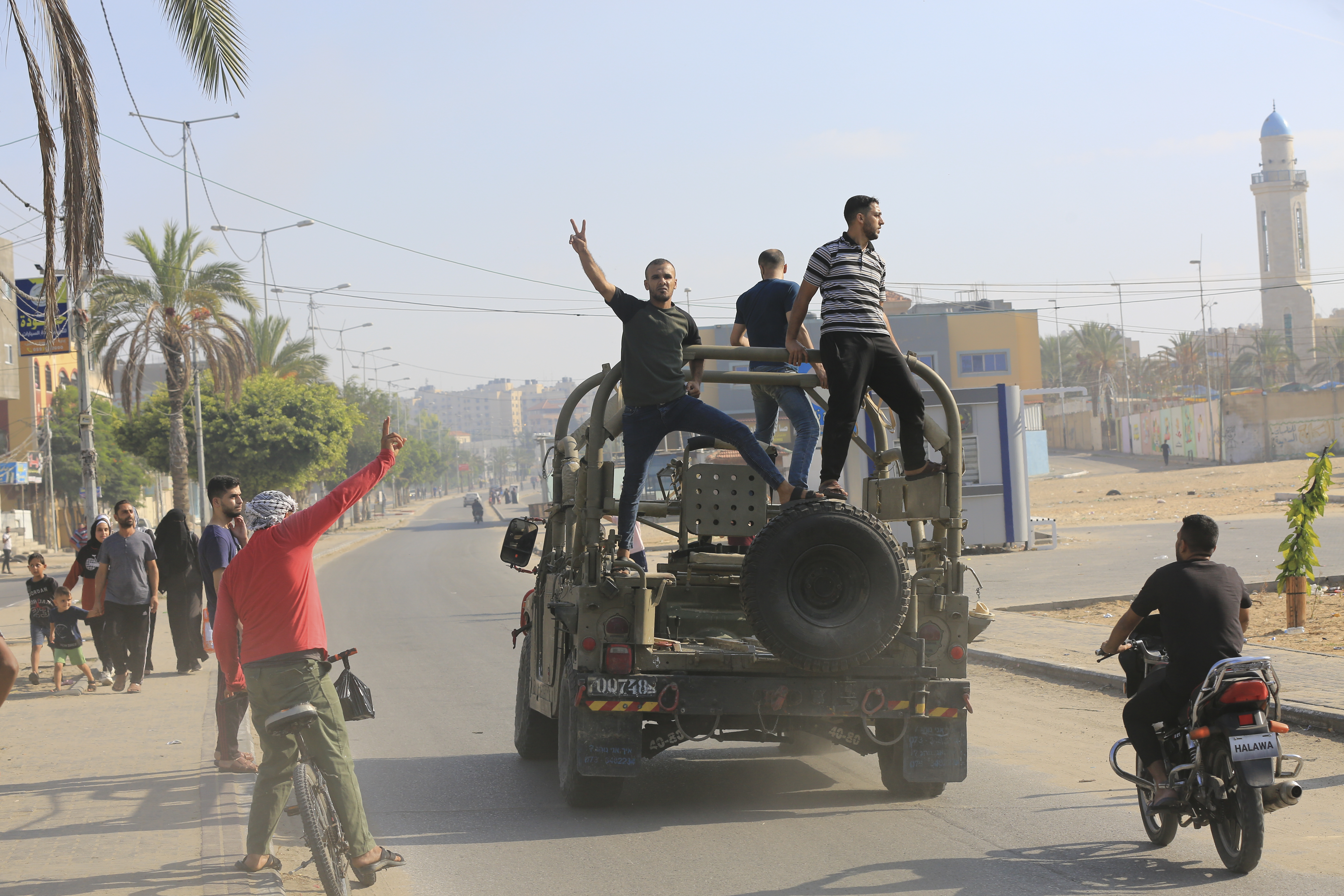 Palästinenser fahren mit einem israelischen Militärfahrzeug in der Nähe eines von Hamas-Kämpfern überrannten Armeestützpunkts in der Nähe des Zauns zum Gazastreifen