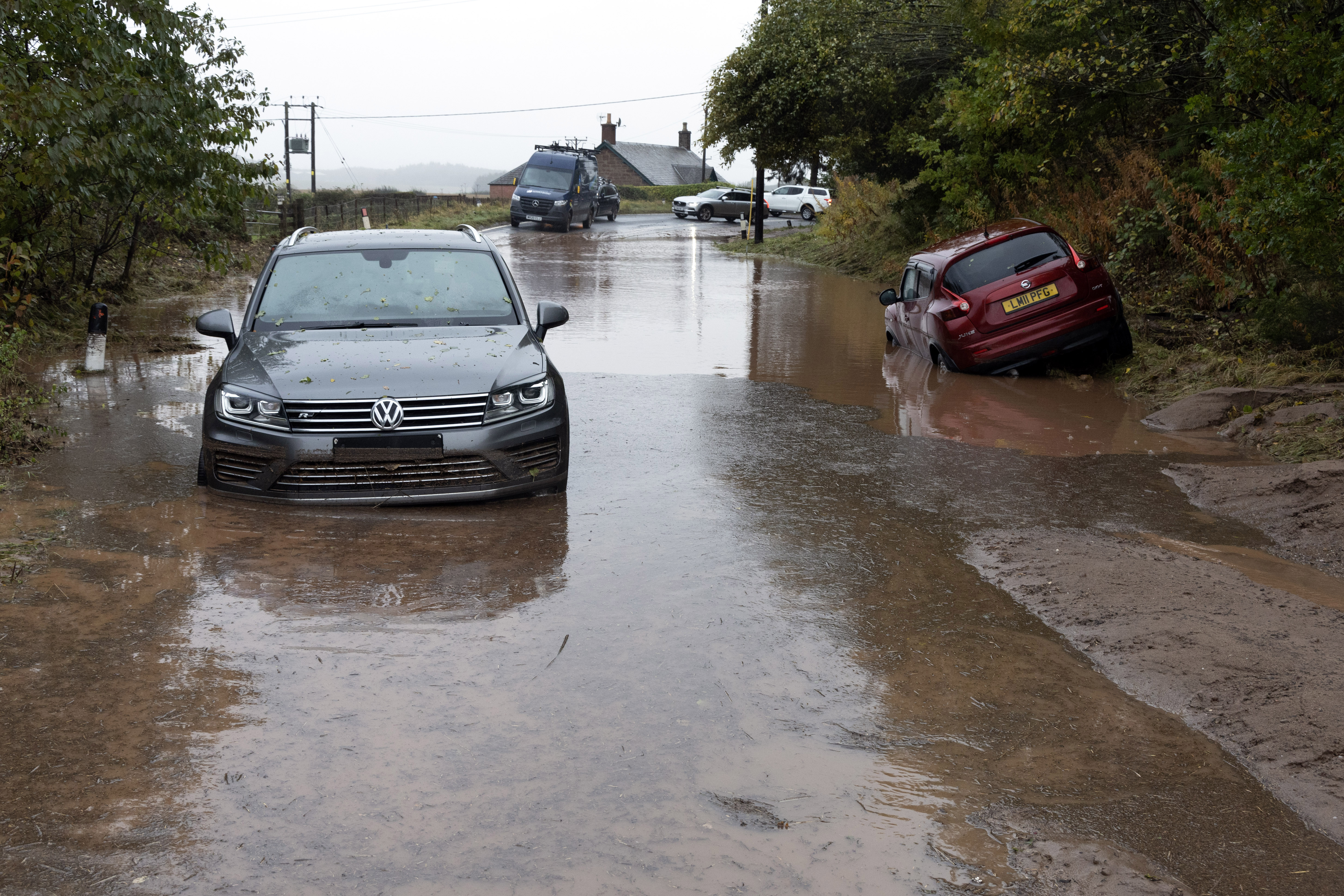 Vehicles stuck and abandoned in muddy floodwater in Perthshire, Scotland