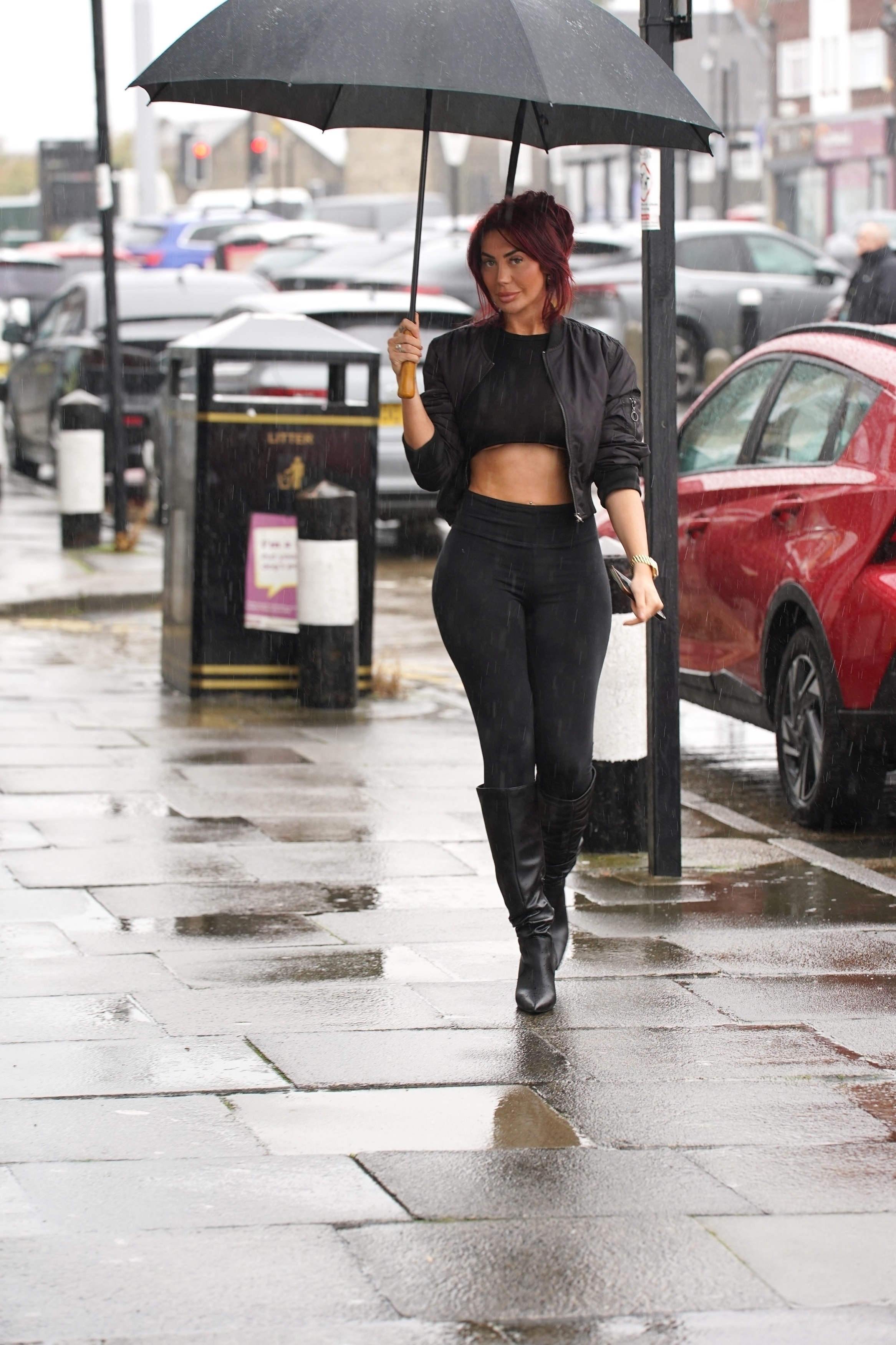 Sie versteckte sich unter einem schwarzen Regenschirm, als sie in Newcastle ausstieg