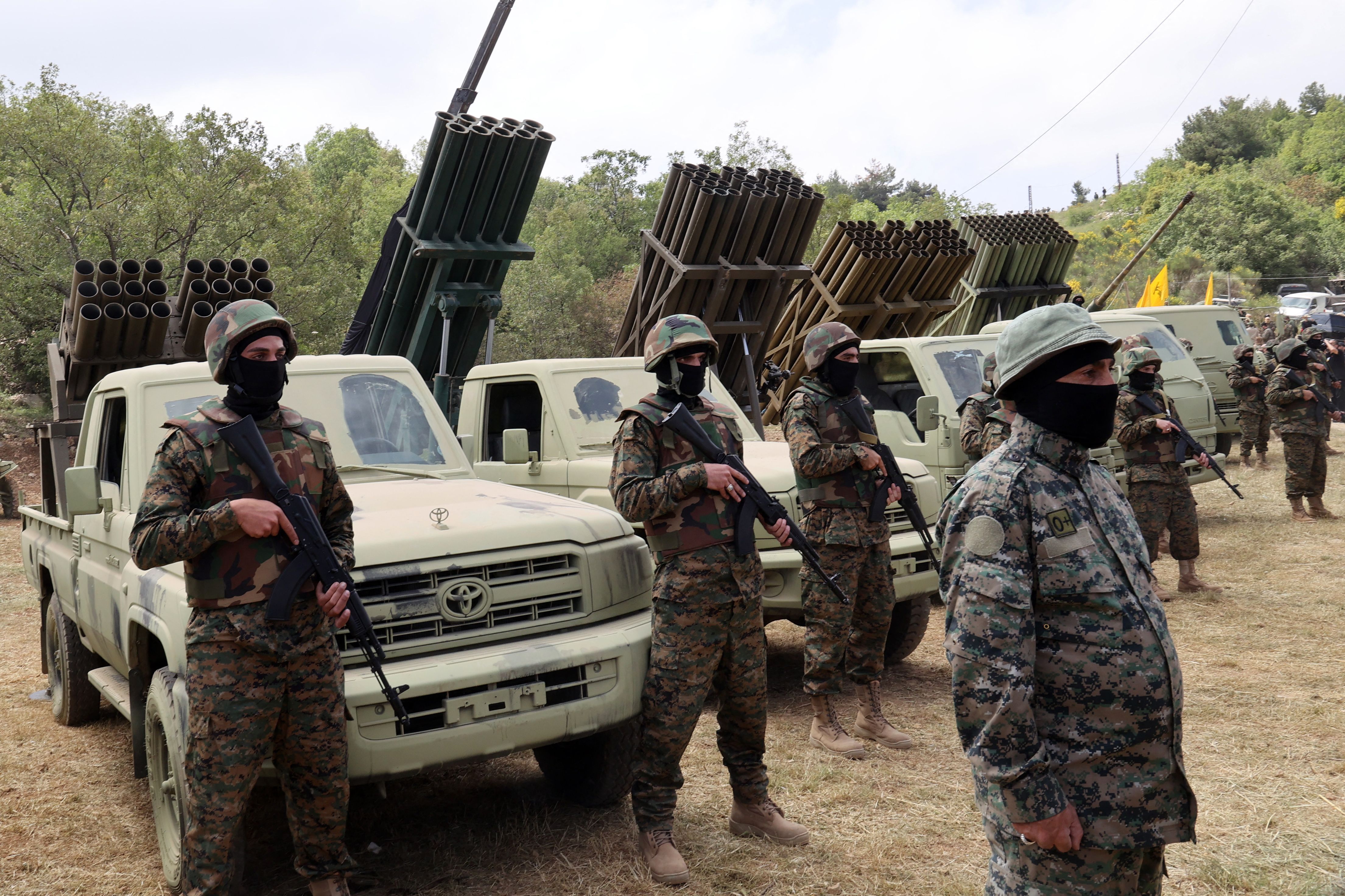 Libanesische Hisbollah-Kämpfer stehen in der Nähe mehrerer Raketenwerfer