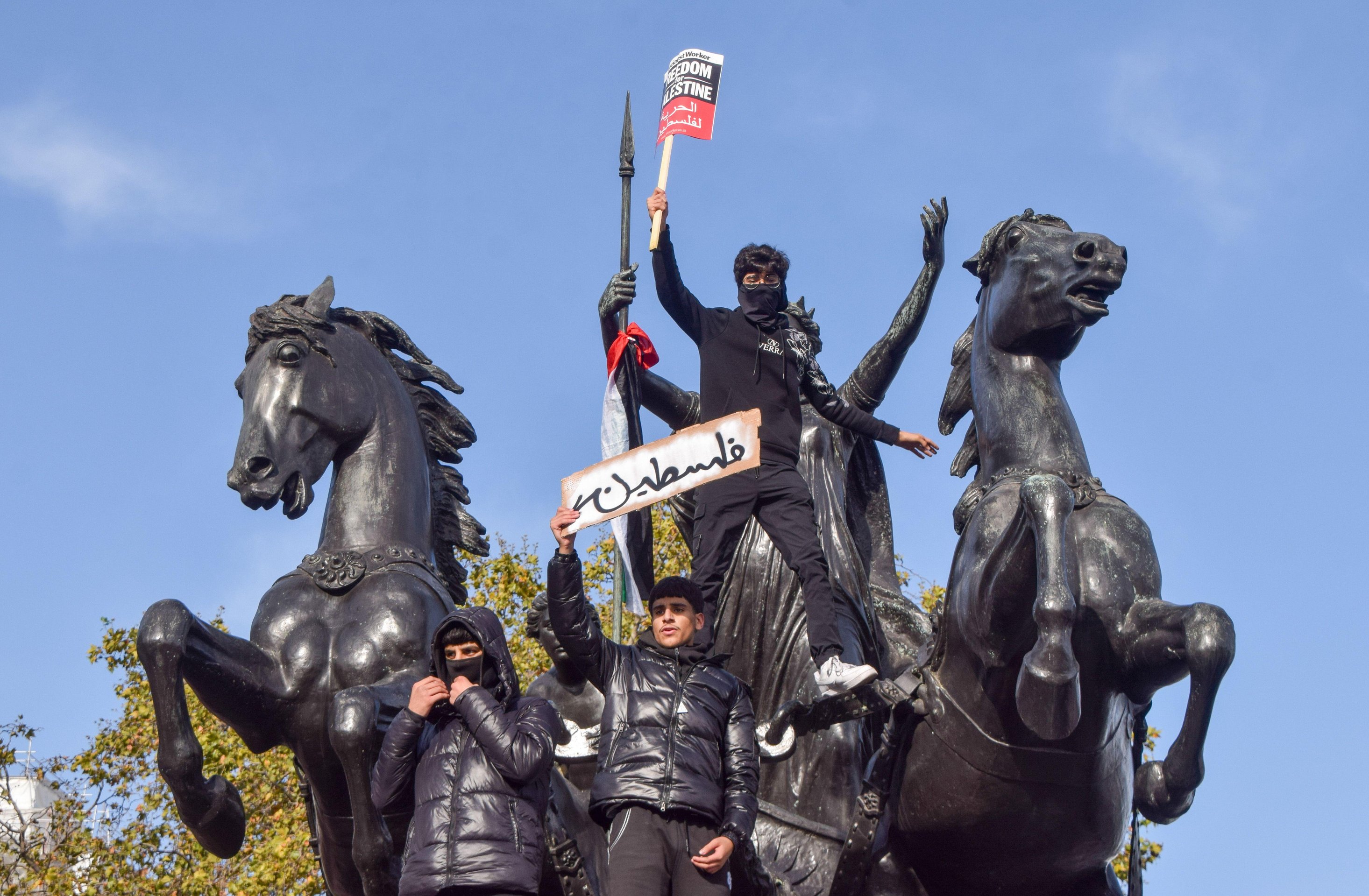 Unter den wachsamen Blicken der beobachtenden Polizei kletterten Demonstranten auf Londoner Denkmäler