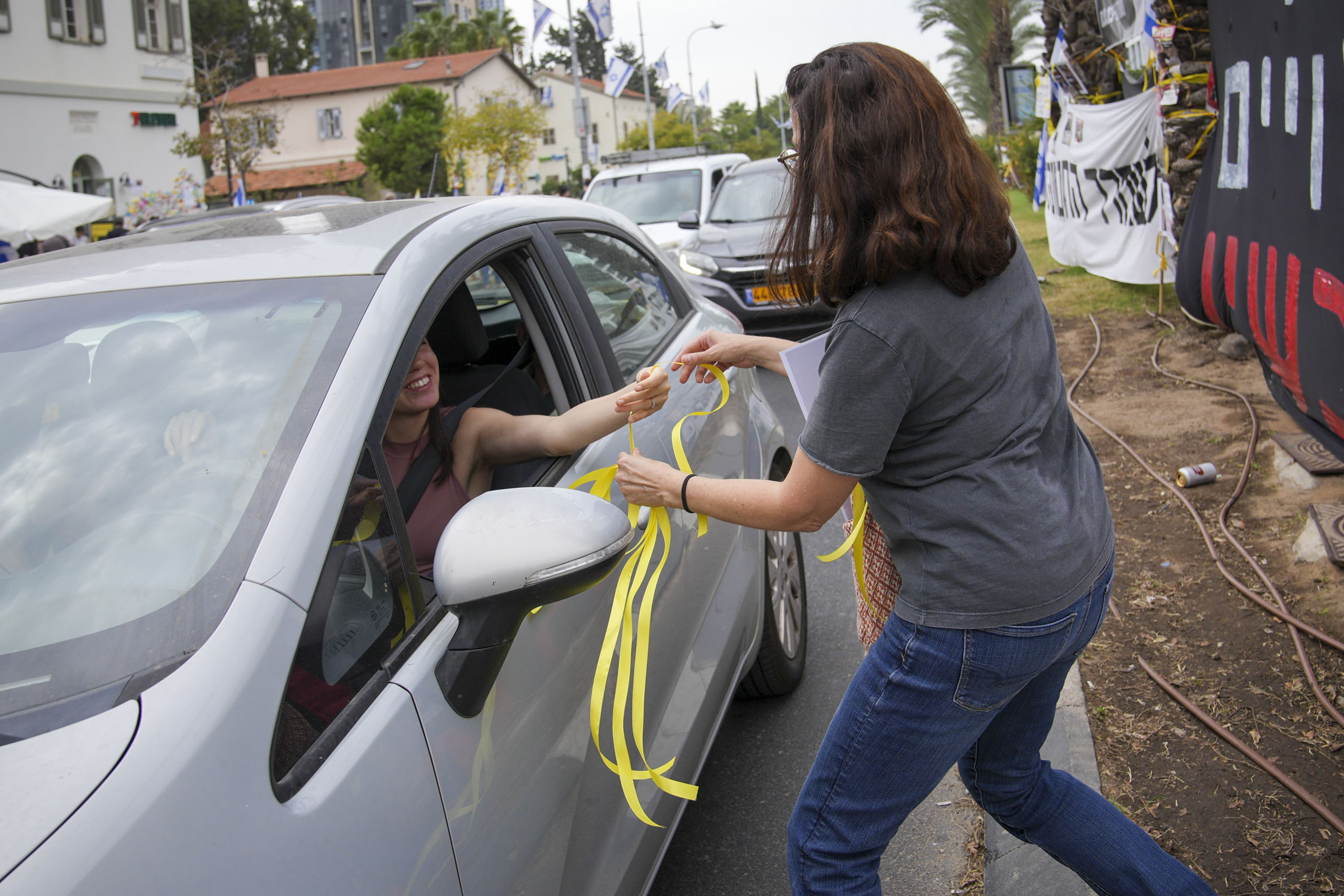 Im Rahmen einer Aktion zur Befreiung der Entführten verteilen Freiwillige gelbe Bänder an vorbeifahrende Autofahrer