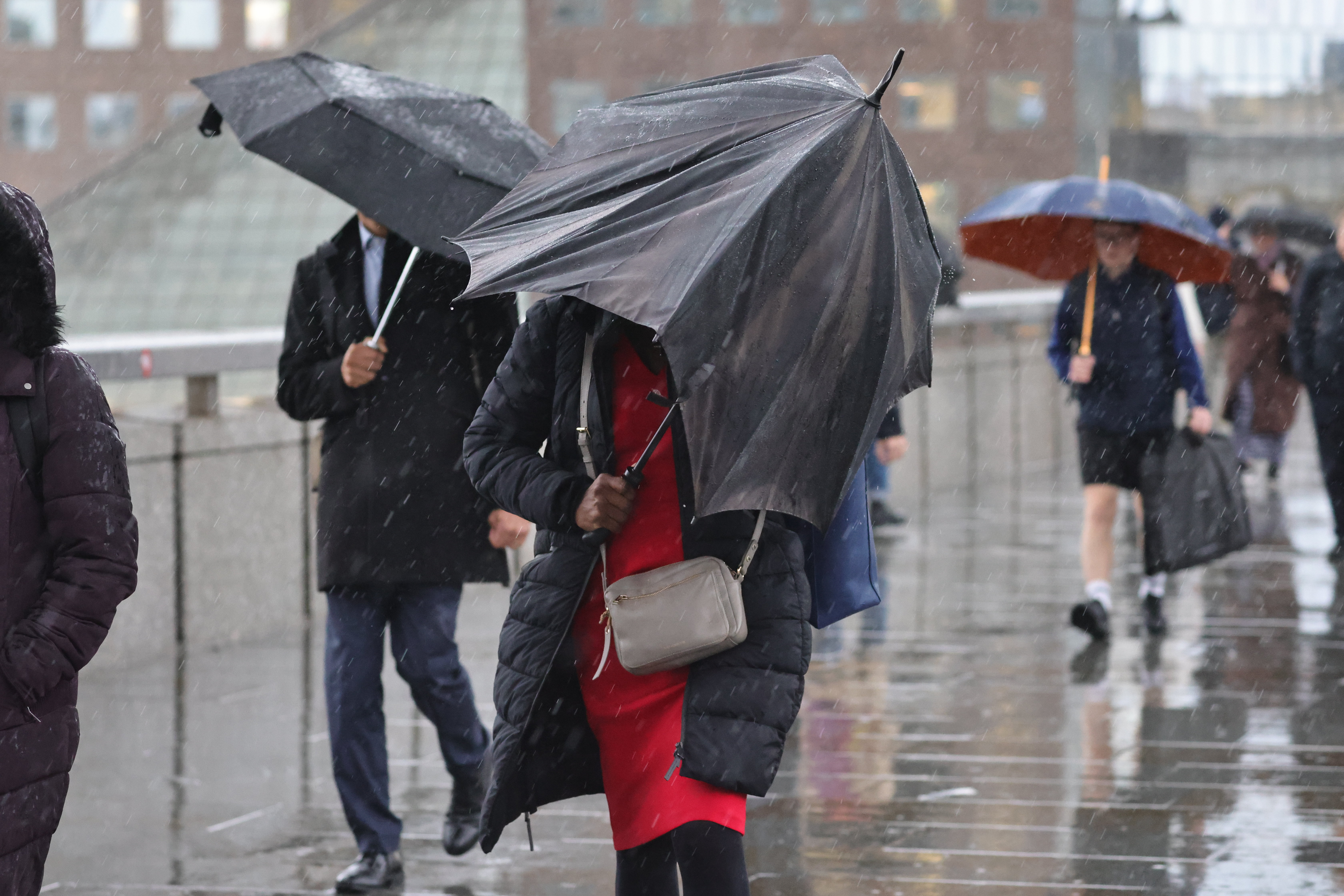 Pendler im Zentrum Londons trotzen starkem Regen