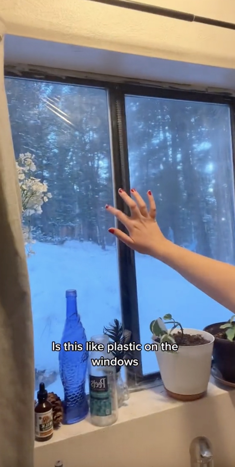 Sie hat Plastik an ihren Fenstern angebracht, um dreißig Prozent der Zugluft fernzuhalten