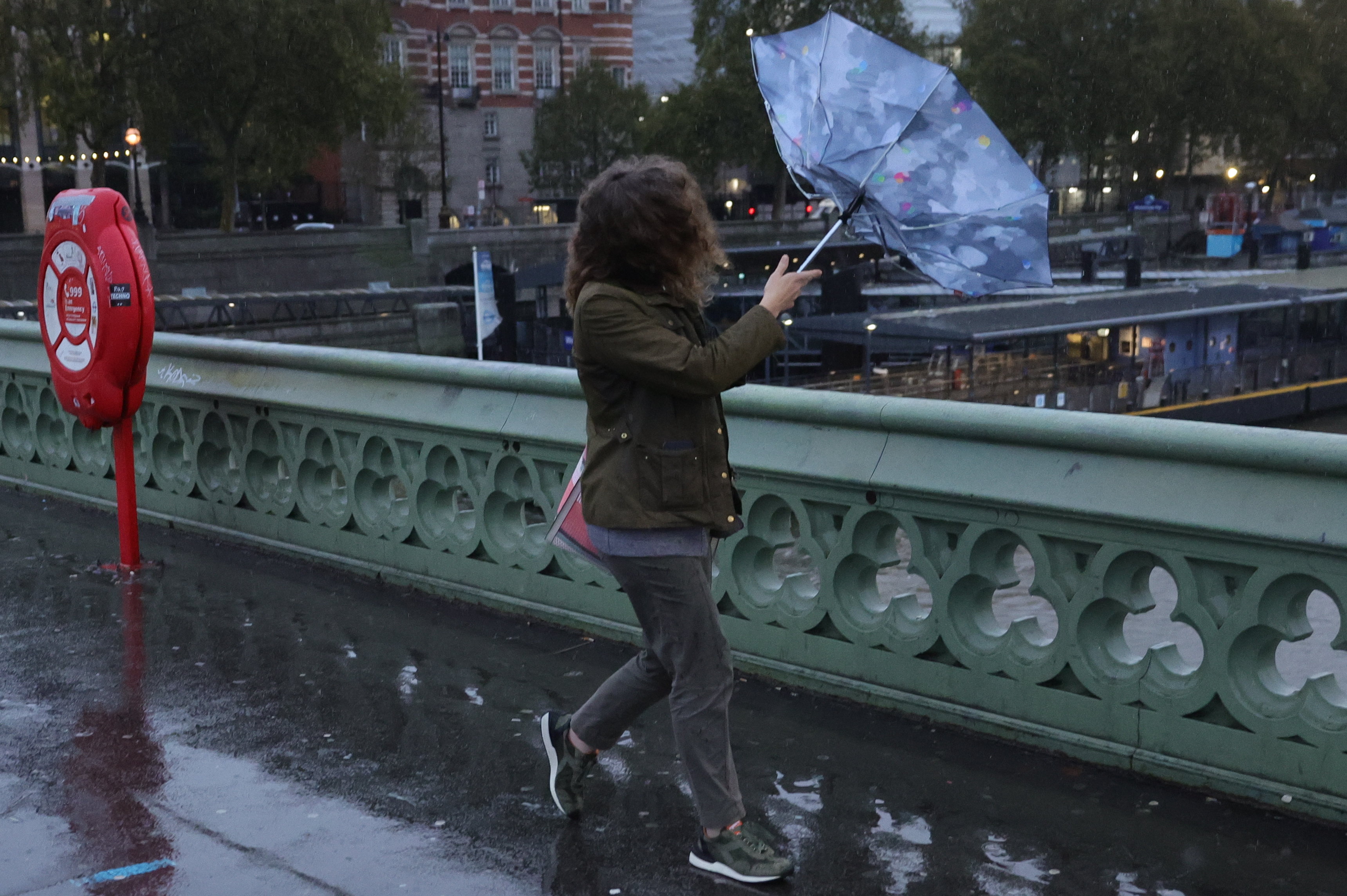 Mitglieder der Öffentlichkeit versuchen bei nassem und windigem Wetter auf der Westminster Bridge Schutz zu suchen