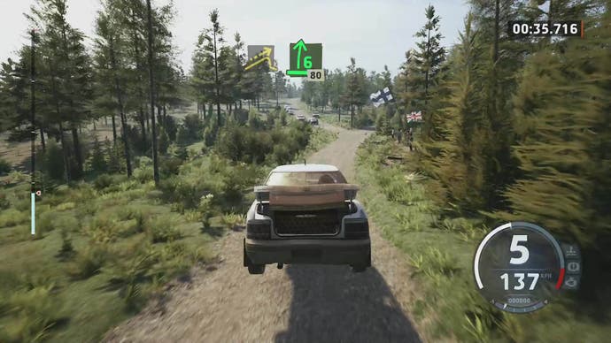 EA Sports WRC-Rezension 8: Eine Aufnahme eines staubigen Subaru in der Luft, mit offenem Kofferraum, umgeben von Bäumen.