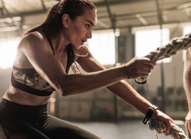 Frau macht Kampfseile, Konzept von HIIT-Workouts zur Gewichtsreduktion