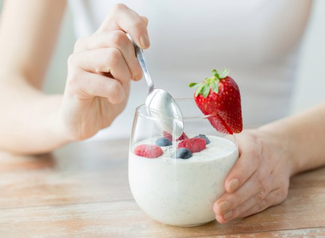 Frau isst Joghurt, das Konzept, dass das Essen von Joghurt Ihnen beim Abnehmen helfen kann