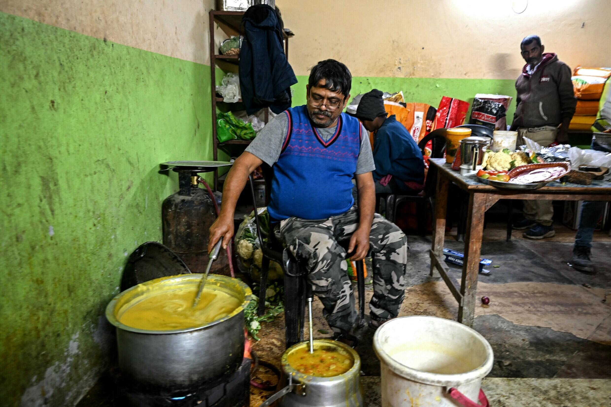 Ein Mann bereitet am 24. November 2023 Essen für Arbeiter zu, die unter dem eingestürzten, im Bau befindlichen Silkyara-Straßentunnel im Bezirk Uttarkashi im indischen Bundesstaat Uttarakhand eingeschlossen sind.