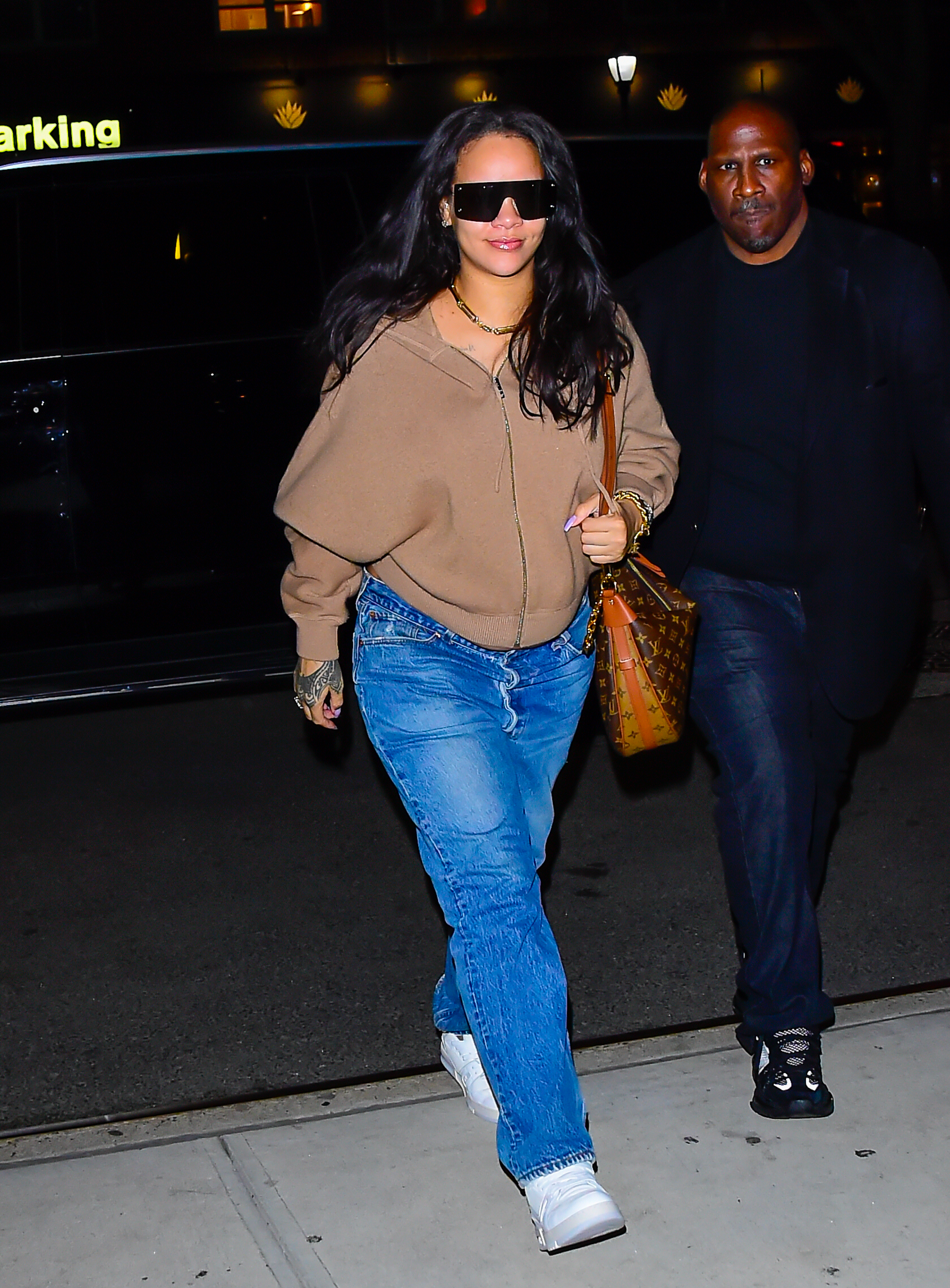 Rihanna trug Jeans lässig mit Sneakers und einem Hoodie sowie mit einem Statement-Mantel