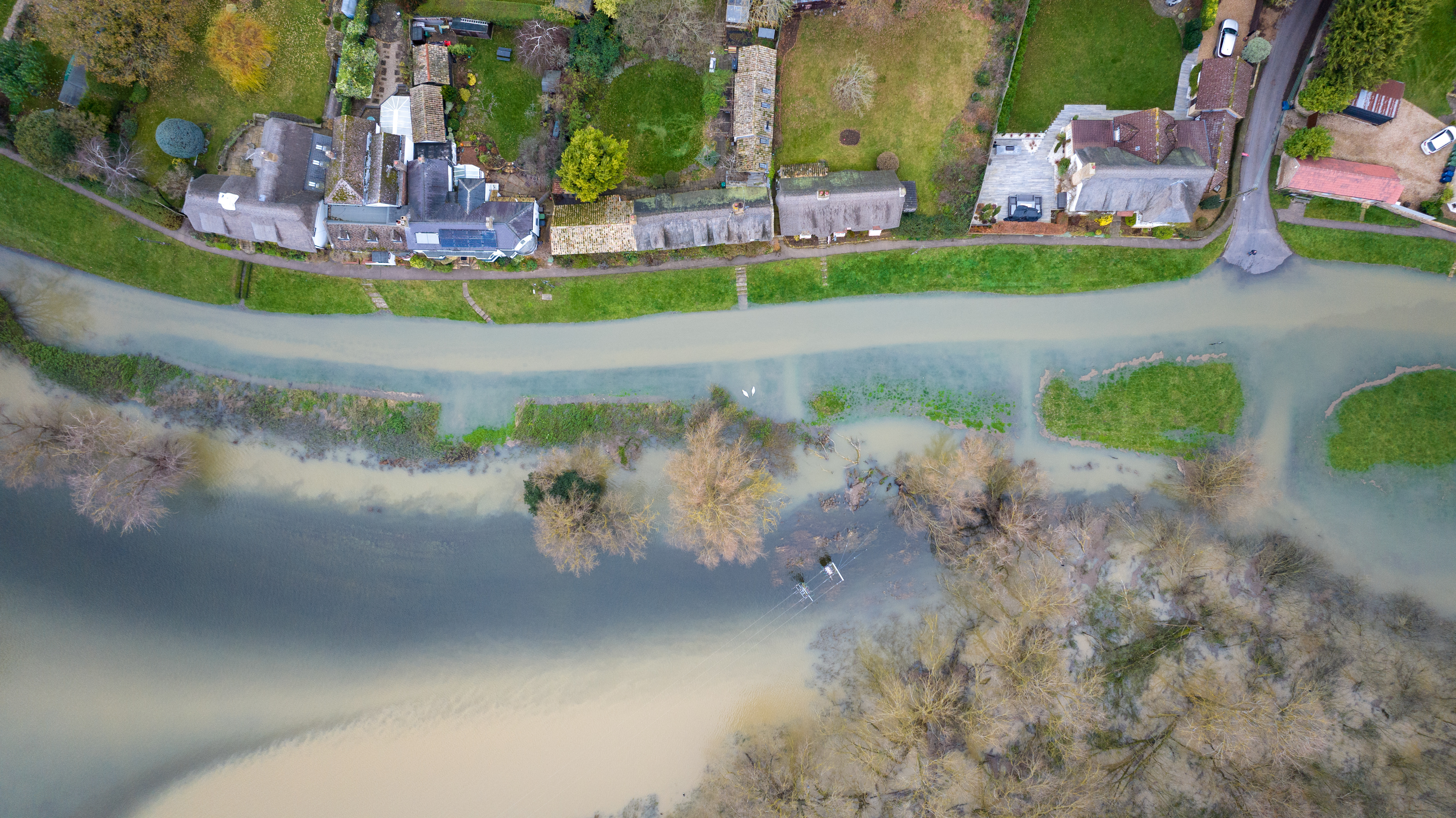 Überschwemmungen entlang der High Street und der umliegenden Felder im Dorf Holywell in Cambridgeshire am Sonntagmorgen, nachdem der Fluss Great Ouse über die Ufer getreten war