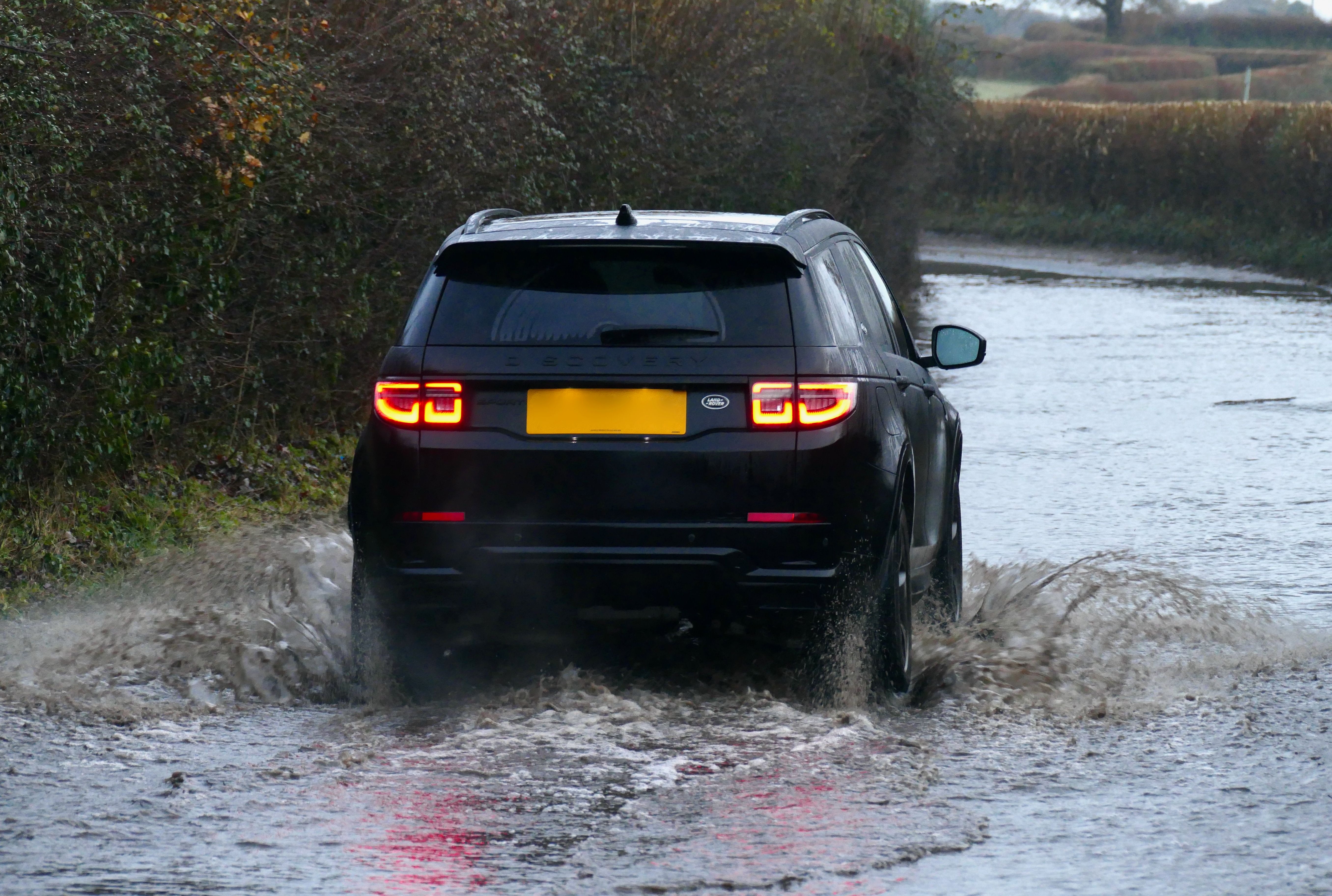 Heute Morgen fahren Autos durch überflutete Landstraßen in Dunsden, Oxfordshire