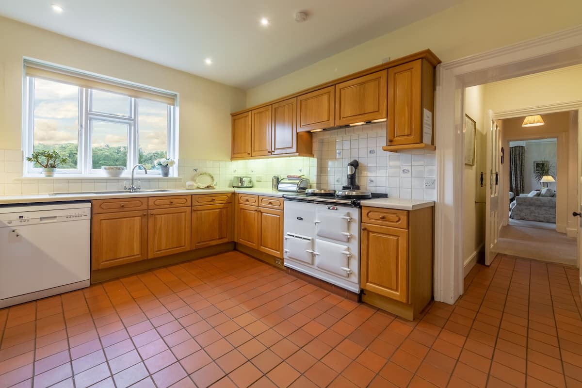 Die Küche verfügt über einen Backofen und einen Geschirrspüler, während es ein Wohnzimmer mit Blick auf den Garten gibt