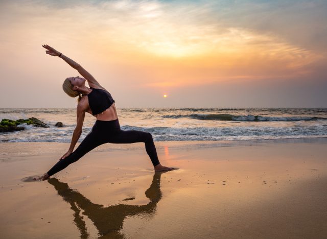 Frau mittleren Alters Yoga bei Sonnenuntergang