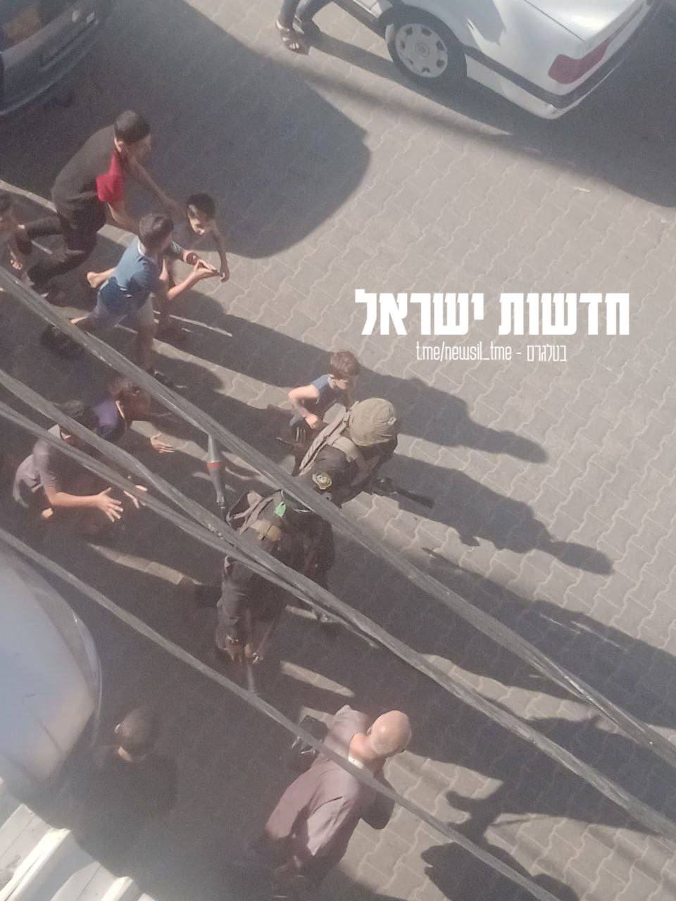 Hamas-Terroristen gehen umgeben von Kindern durch die Straßen