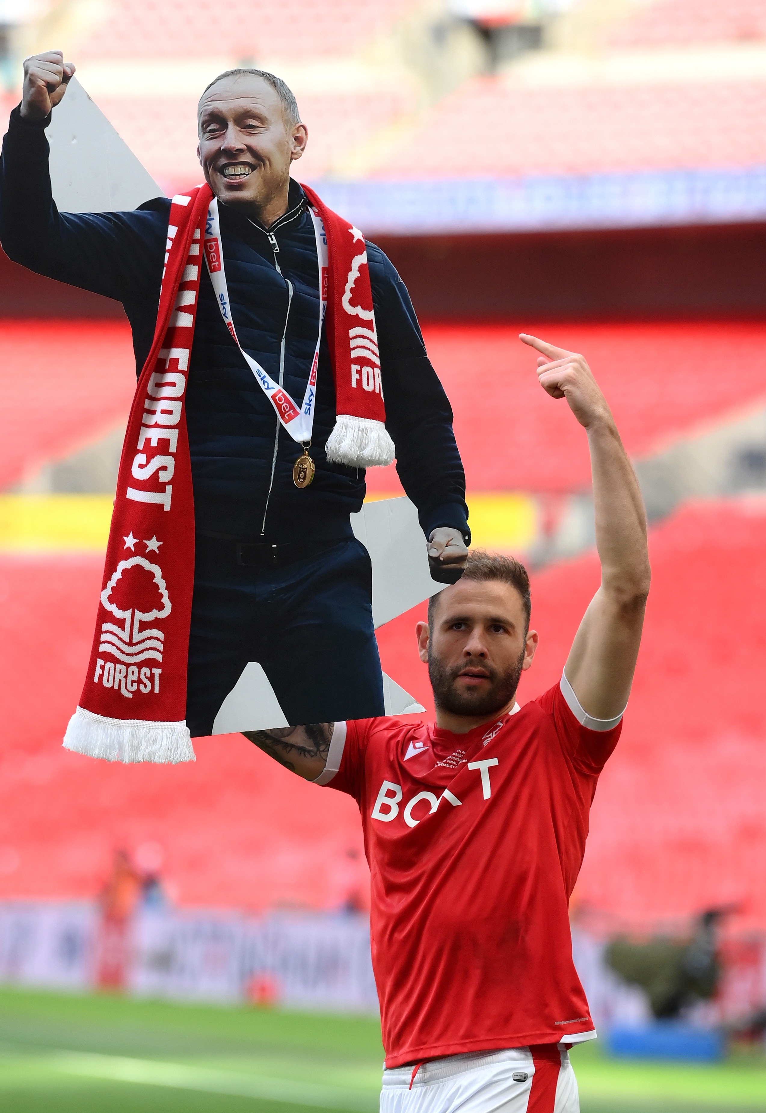 Steve Cook hält im Wembley-Stadion einen Pappausschnitt von Steve Cooper hoch, nachdem Nottingham Forest im Play-off-Finale den Aufstieg gewonnen hat