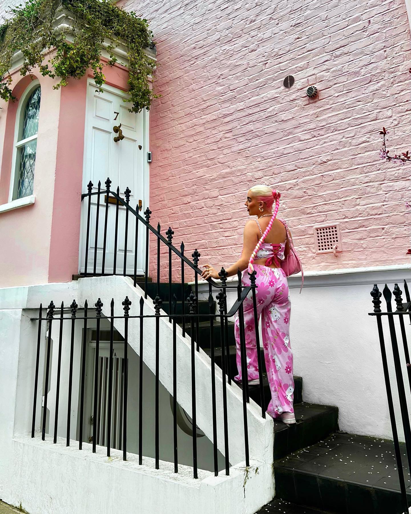 Poser machen Fotos auf seinen Stufen und vor seinen rosa gestrichenen Wänden