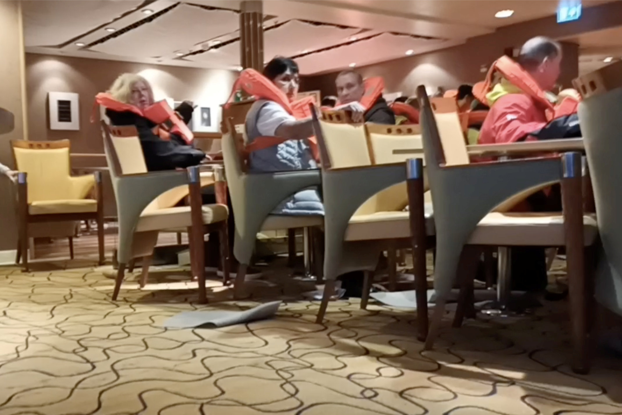 Passagiere in Schwimmwesten machen es sich an Bord der MS Maud auf Stühlen bequem