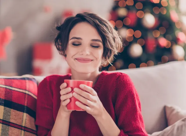 Glückliche Frau feiert Urlaub Kaffee auf der Couch