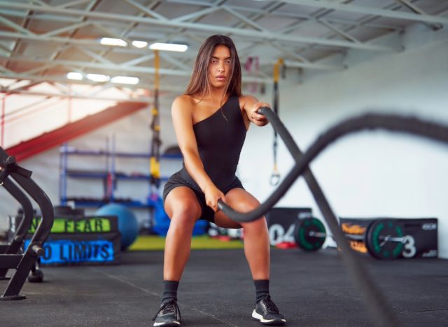 Fitte Frau beim Kampfseiltraining, Konzept von HIIT-Übungen zur Gewichtsabnahme
