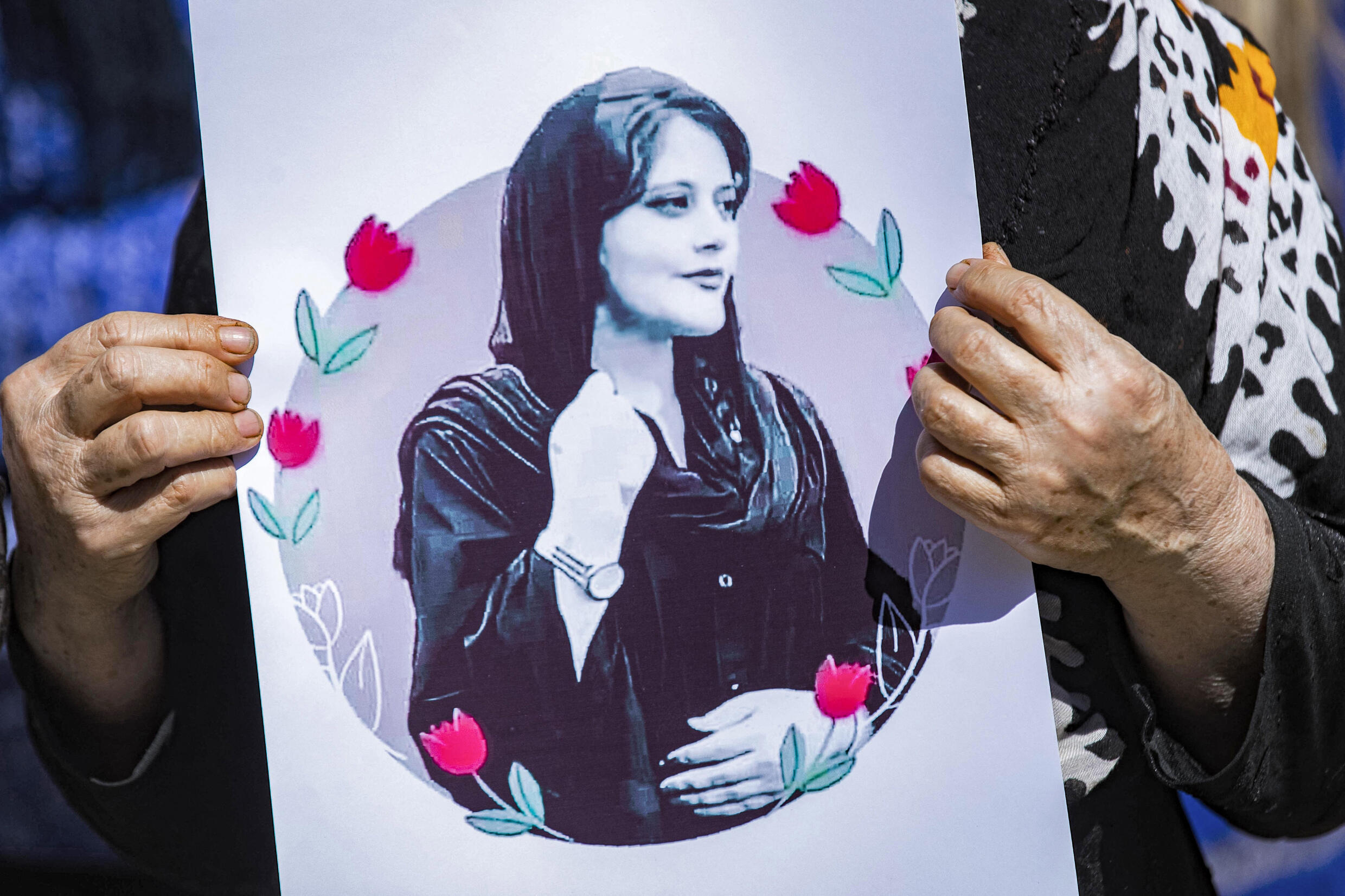 Eine Frau hält am 25. September 2022 bei einer Solidaritätsdemonstration in Hasakeh im kurdischen Nordosten Syriens ein Plakat mit einem Bild von Mahsa Amini hoch. 