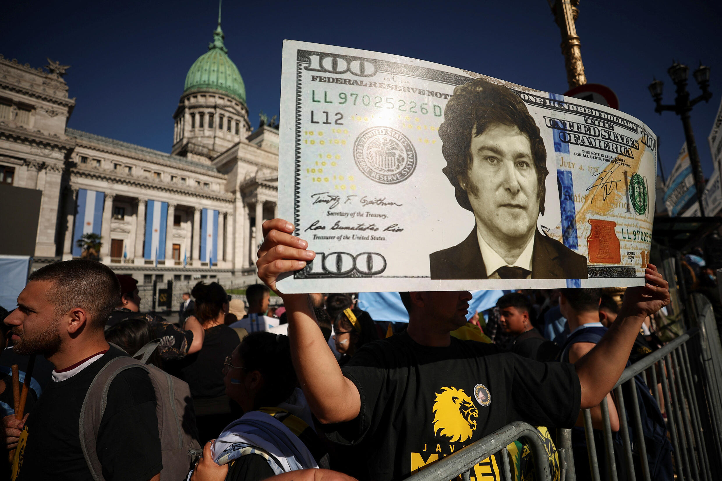 Ein Anhänger von Javier Milei hält am 10. Dezember 2023 in Buenos Aires, Argentinien, einen gefälschten 100-Dollar-Schein hoch, auf dem sein Lieblingskandidat abgebildet ist.