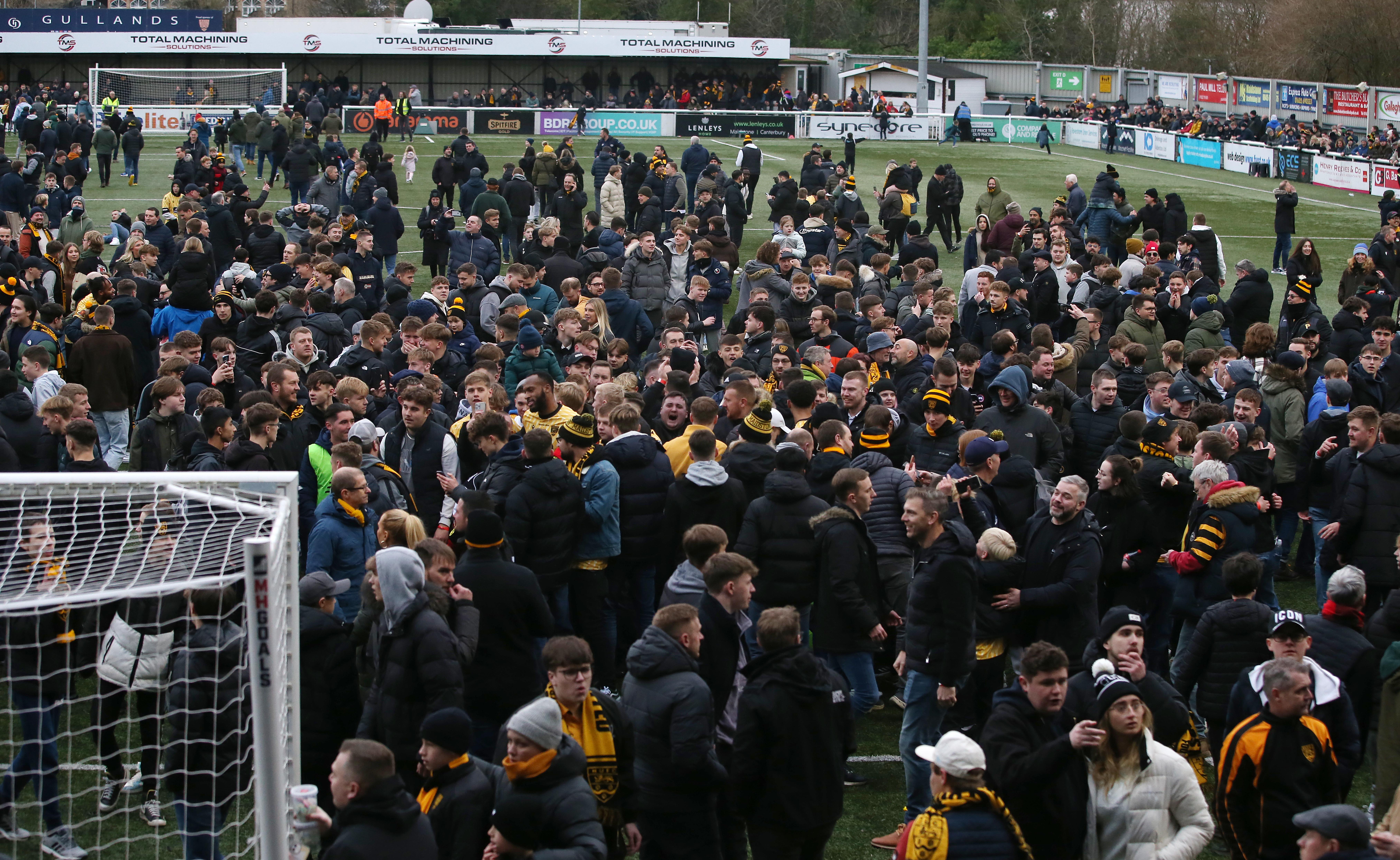Rund 1.000 Maidstone-Fans strömen nach dem historischen Sieg vor Freude über das Spielfeld