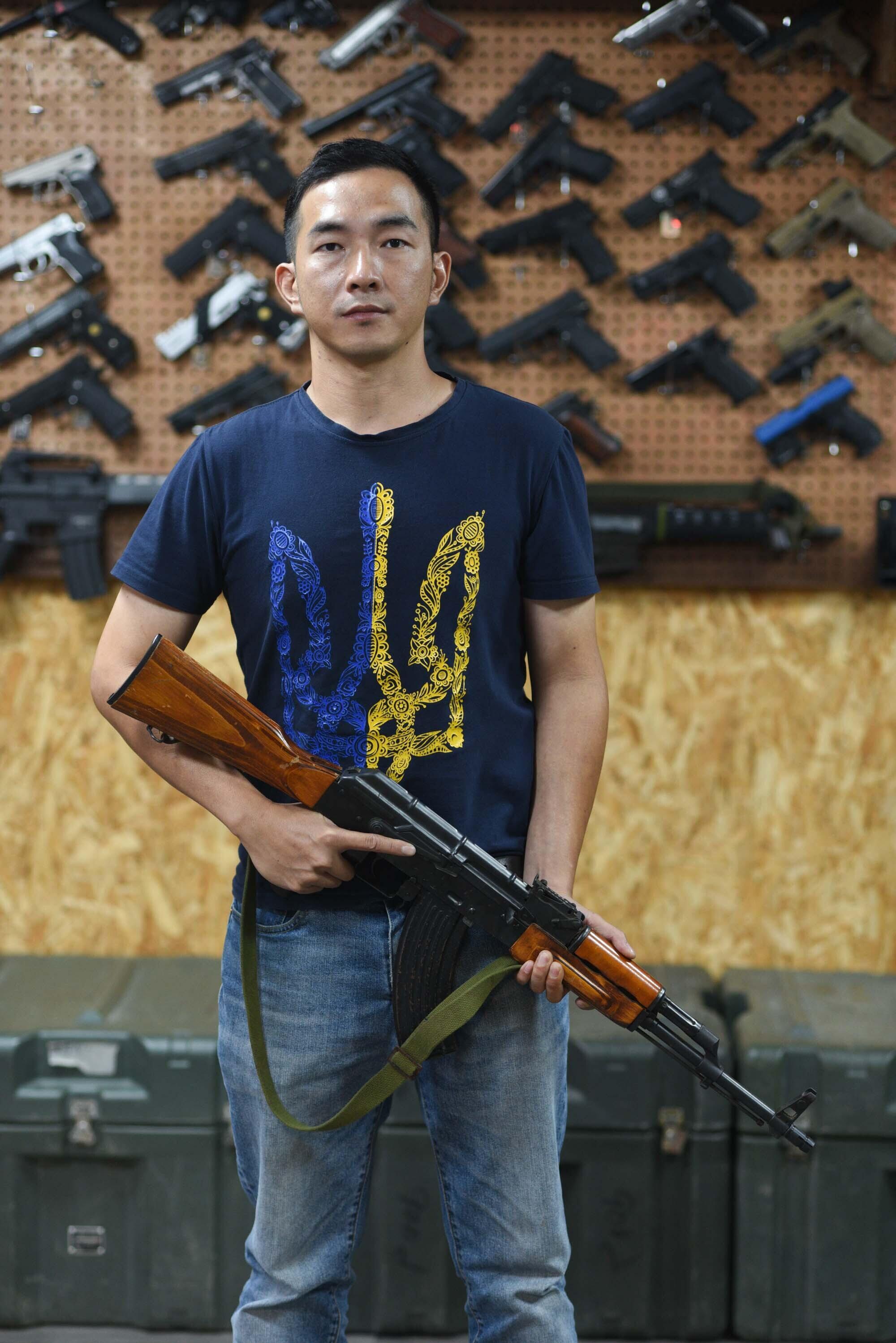 Tony Lu posiert mit einer AK-47-Airsoft-Nachbildung im Lager 66. Er ist in ganz Taiwan dafür bekannt, dass er 2022 in der internationalen Legion der Ukraine gekämpft hat. Jetzt fordert er seine Landsleute auf, sich auf den Fall einer chinesischen Invasion vorzubereiten.