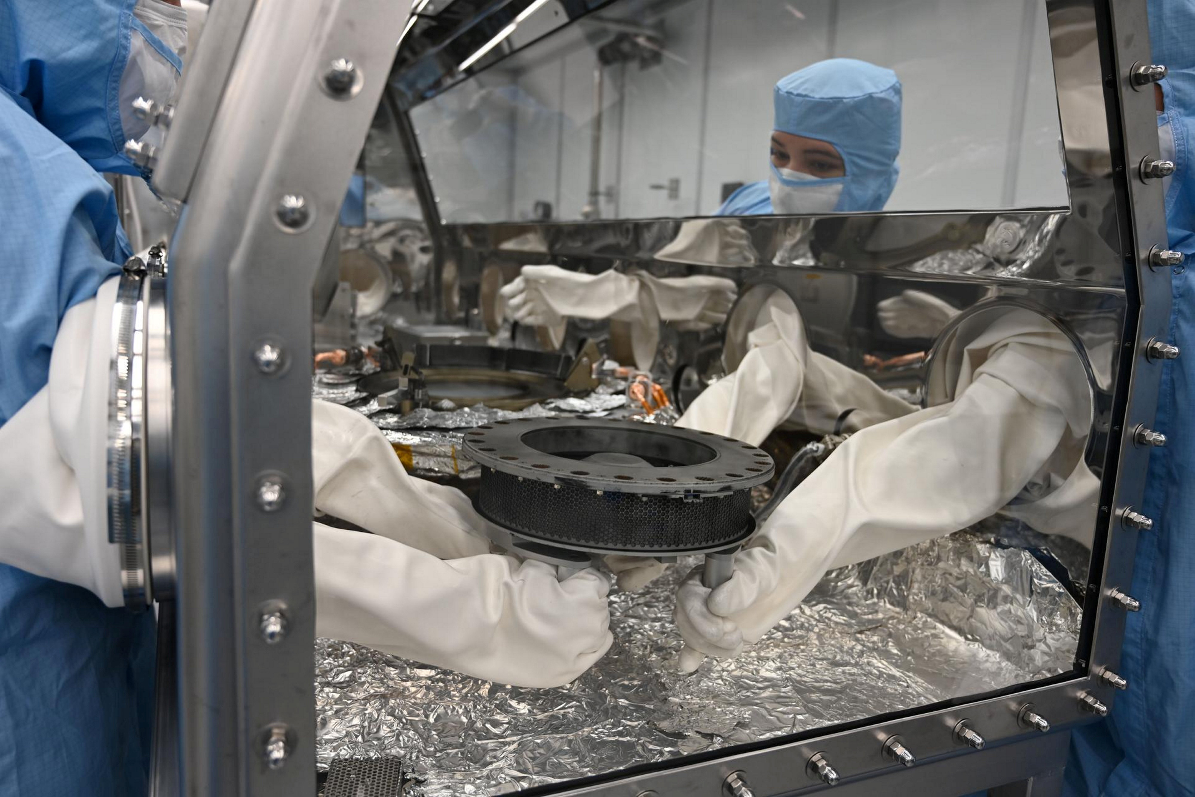 Das NASA-Team legt das TAGSAM im Handschuhfach ab, um eine Kontamination nach dem Entfernen aus der Sonde zu verhindern