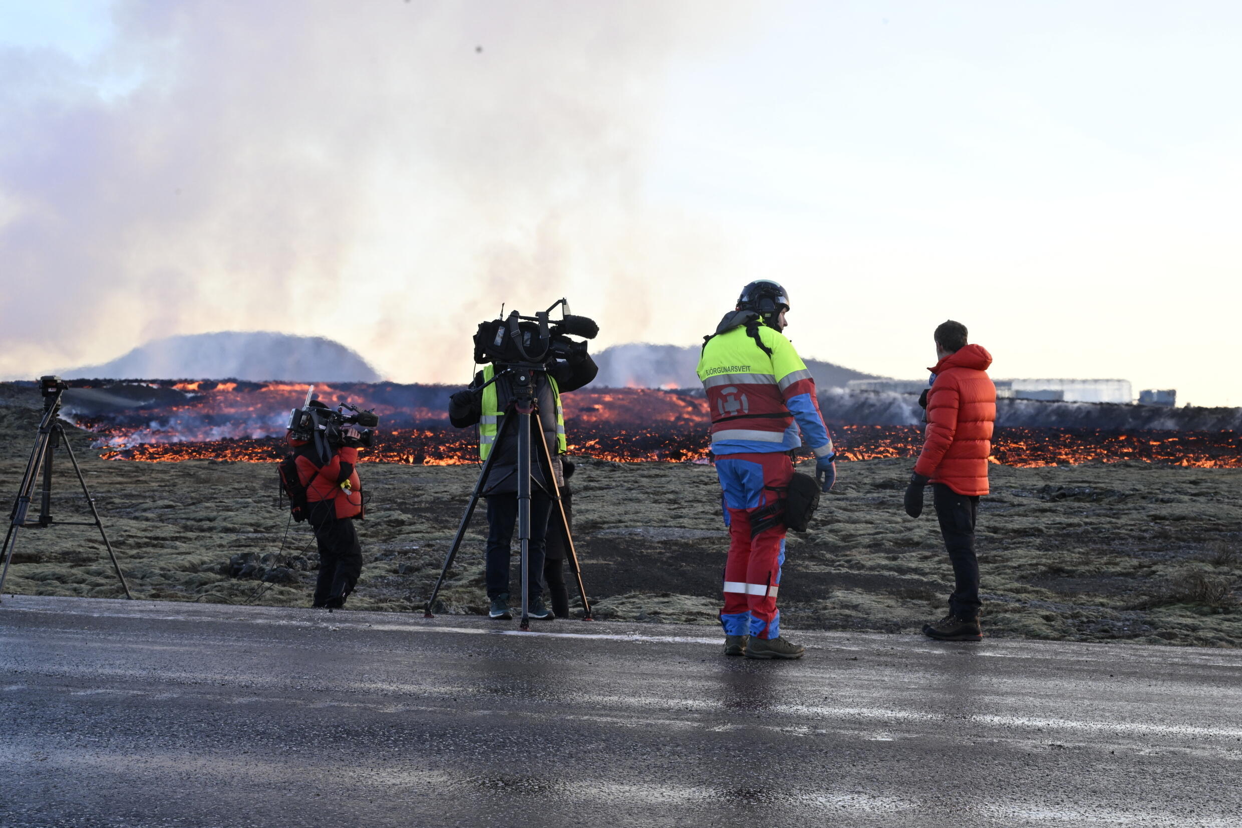 Medien und Einsatzkräfte beobachten, wie sich am 14. Januar 2024 fließende Lava einer Straße am Rande der südwestlichen isländischen Stadt Grindavik nähert.