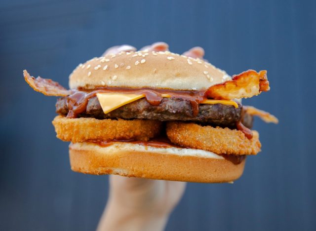 Person hält Carl's Jr. Western Bacon Cheeseburger