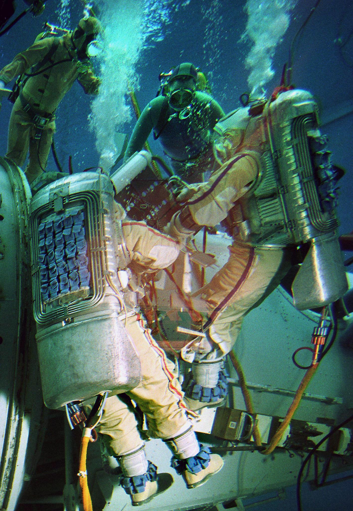 Ein Team von Kosmonauten arbeitet unter Wasser an einem Raumschiff