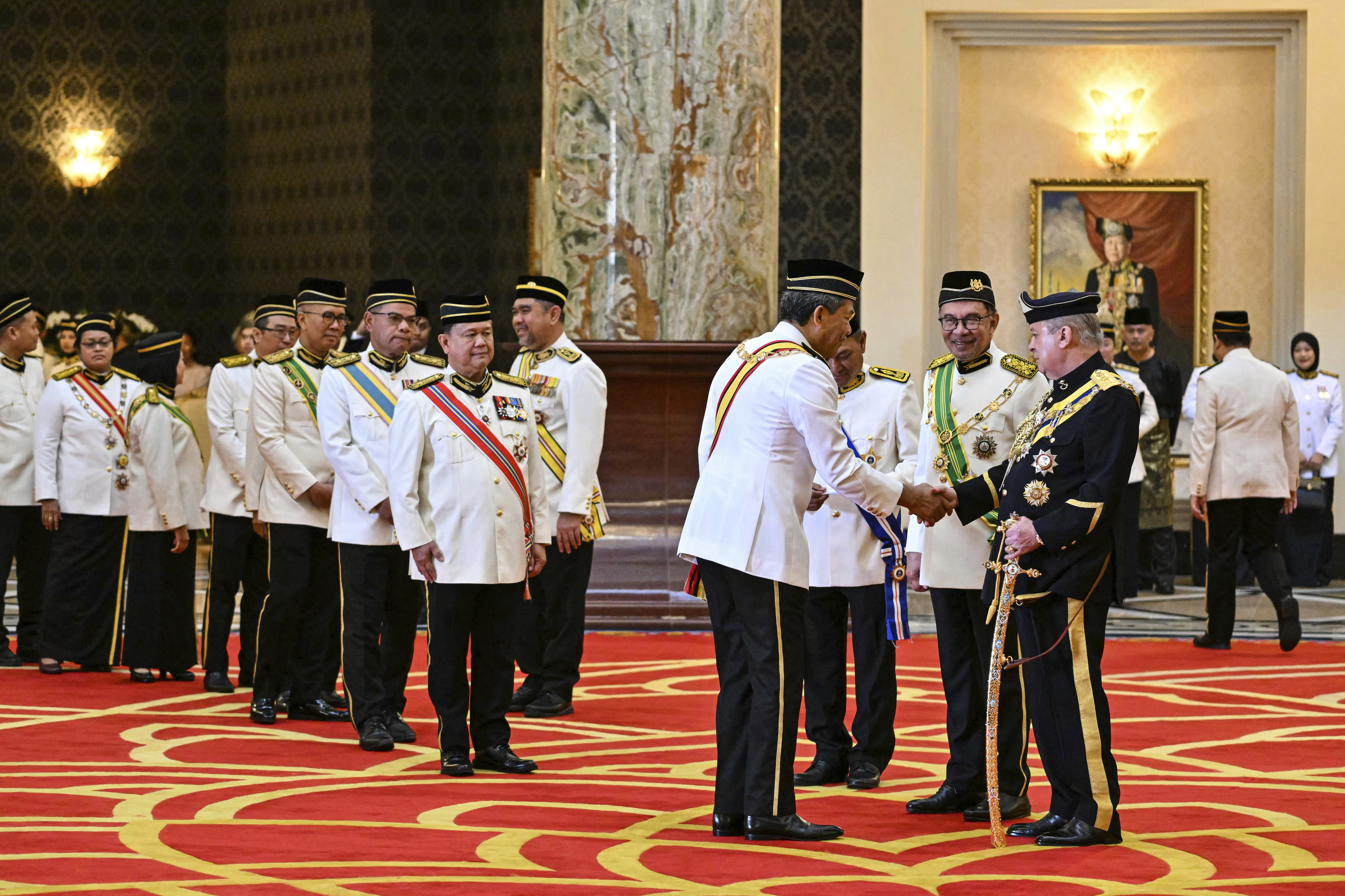 Mitglieder der malaysischen Regierung warten darauf, dem neuen Monarchen (Bild rechts) nach der Eidzeremonie im Nationalpalast in Kuala Lumpur die Hand zu schütteln