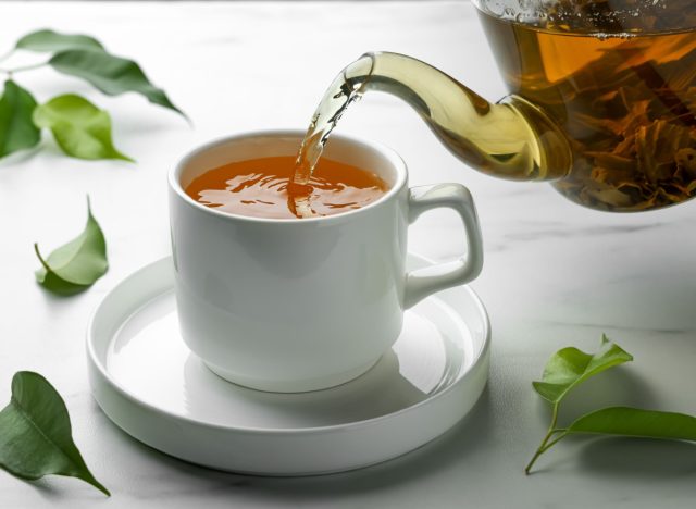 Grünen Tee in eine Tasse gießen
