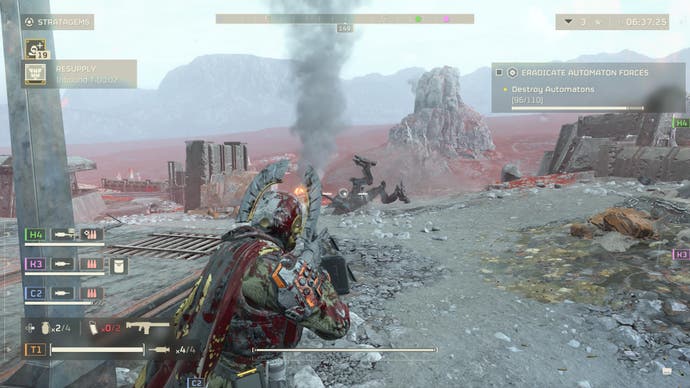 Screenshot von Helldivers 2, der einen blutüberströmten Charakter zeigt, der auf einen umgekippten Mech zielt, dessen Beine in der Luft wackeln.